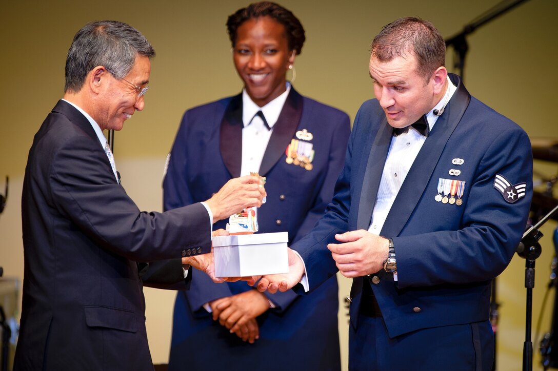 SHIOGAMA CITY, Japan -- Senior Airman William Pressgrove, Band of the Pacific-Asia vocalist, accepts a gift on Pacific Trends behalf from Mr. Akira Sato, Shiogama City mayor, at the Yu Hall, Shiogama City, Miyagi Prefecture, Japan on Aug 7, 2012. Following the presentation, Sato thanked the band for the performance, stating his own gratitude in English. (U.S. Air Force photo/Staff Sgt. Josh Voyles)