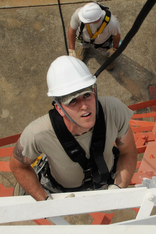Senior Airman Joshua Newell, 8th Communications Squadron airfields systems specialist, climbs a communication tower as Tech. Sgt. Samuel Chytla 8th CS cable antenna, spots him on his assent to the middle of the tower at Kunsan Air Base, Republic of Korea, Aug. 8 2012. The Airmen took turns rescuing each other as a part of their yearly training for their job. (U.S. Air Force photo/Senior Airman Marcus Morris)