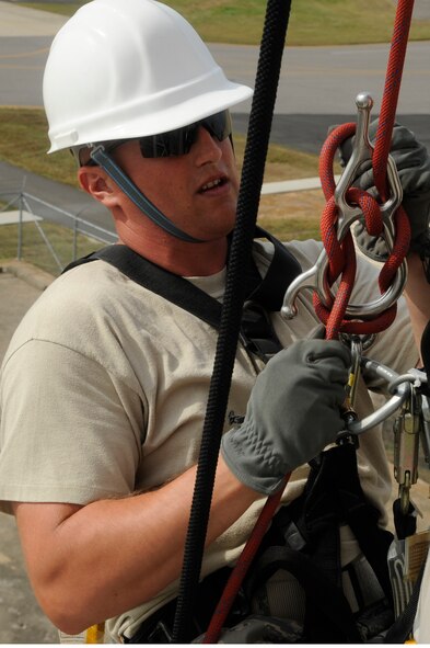 Staff Sgt. Joel Avant, 8th Communications Squadron radio frequency transmission systems , hooks himself to another Airman as part of rescue training at Kunsan Air Base, Republic of Korea, Aug. 8 2012. The training is used to get an injured Airman down from a tower when they can no longer get themselves down on their own. (U.S. Air Force photo/Senior Airman Marcus Morris)