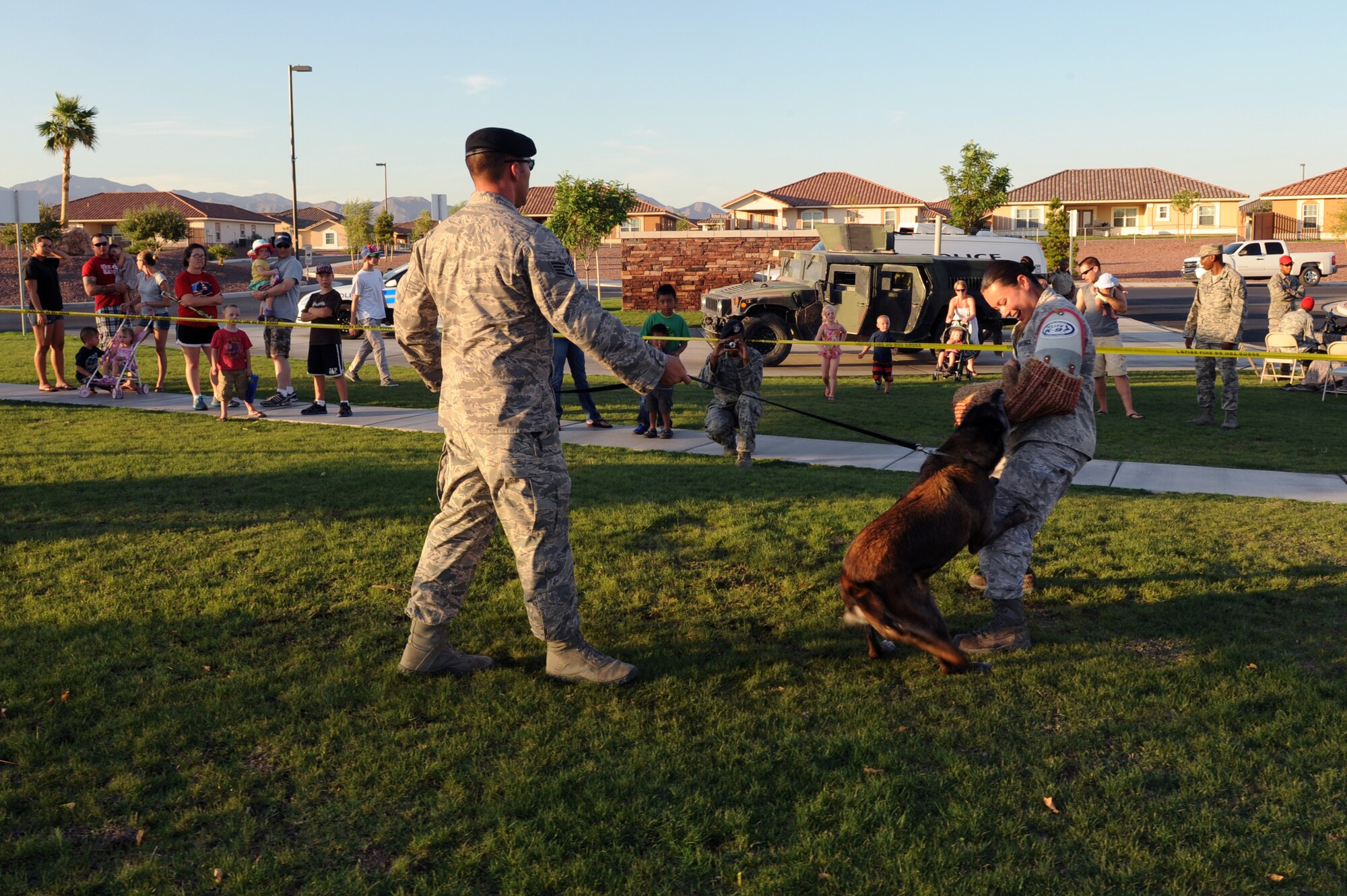 U.S. Air Force Staff Sgt. Bruce Martinez and Senior Airman Rosanne Caballero, 99th Security Forces Squadron military working dog handlers, demonstrate the abilities of Chester, 99th Security Forces Squadron police dog, during "National Night Out" August 8, 2012, at Nellis Air Force Base, Nev. "National Night Out" is a nationwide effort to heighten crime prevention awareness, generate support for local anti-crime programs and strengthen neighborhood spirit and police-community partnerships. (U.S. Air Force photo by Staff Sgt. William P.Coleman)
  

