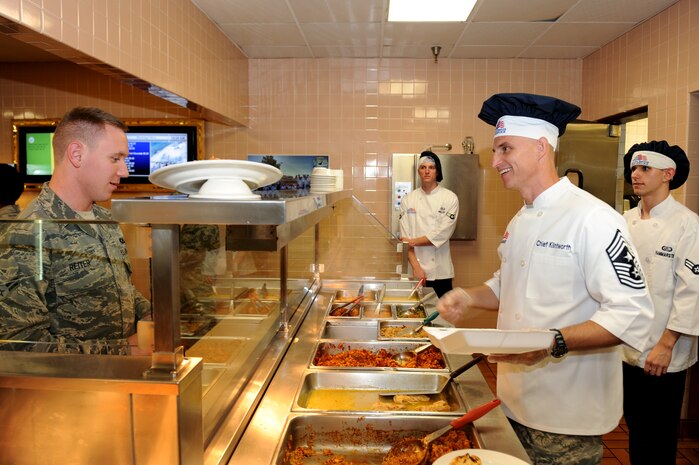 Chief Master Sgt. Michael Klintworth, 57th Wing command chief, serves Airman 1st Class Stephen Reiter, 422 Test and Evaluation Squadron aviation resource management apprentice, lunch August 8, 2012, at Nellis Air Force Base, Nev. Klintworth along with Chief Master Sgt. Vincent Marler, 99th Air Base Wing command chief, talked to Airmen as they went through the Crosswinds Inn Dining Facility to learn about the Airmen in their command.  (U.S. Air Force photo by Staff Sgt. William P.Coleman)  