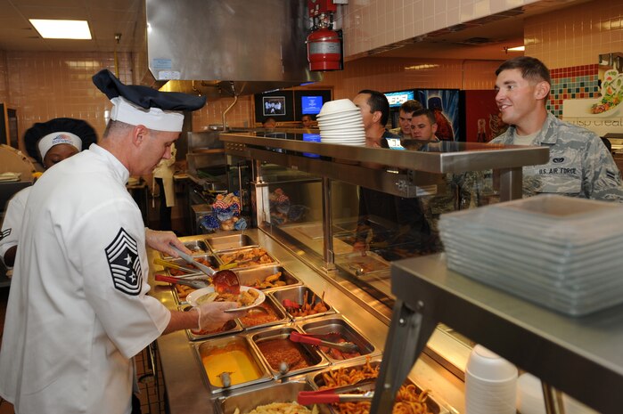 Chief Master Sgt. Vincent Marler, 99th Air Base Wing command chief, serves Airman 1st Class Franklin Edmondson, 820th RED HORSE pavements and construction apprentice, lunch August 8, 2012, at Nellis Air Force Base, Nev. Marler along with Chief Master Sgt. Michael Klintworth, 57th  Wing command chief, talked to Airmen as they went through the Crosswinds Inn Dining Facility to learn about the Airmen in their command. (U.S. Air Force photo by Staff Sgt. William P.Coleman)  