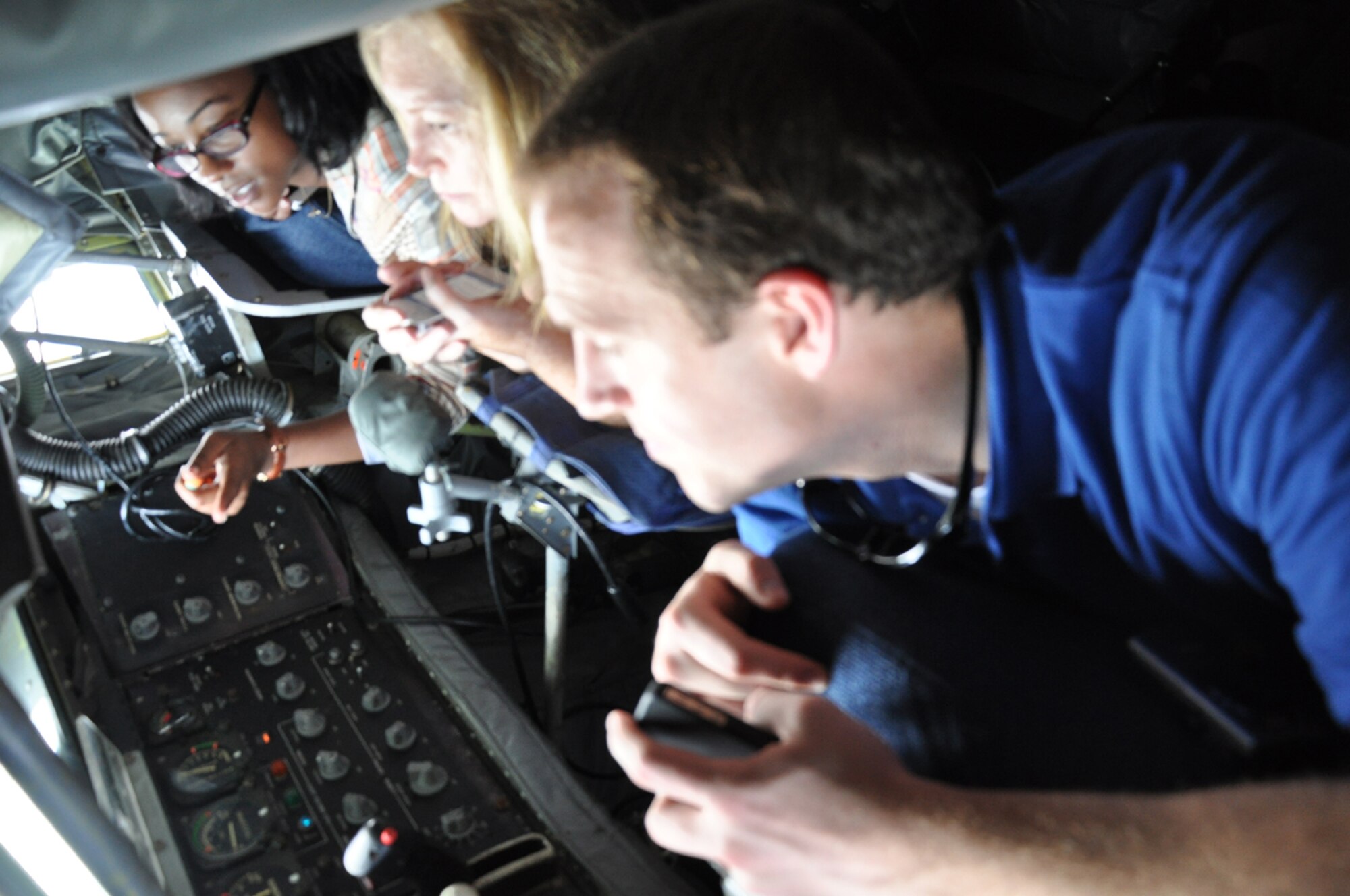 Kyle Parker, Camea Britton and Jewell Massenburg look through the window in the boom operator area of a KC-135R Stratotanker on Aug. 9. The federal staffers flew with the 916th Air Refueling Wing over North Carolina's outer banks as part of an orientation flight. (USAF photo by Ms. Donna Lea, 916ARW/PA)