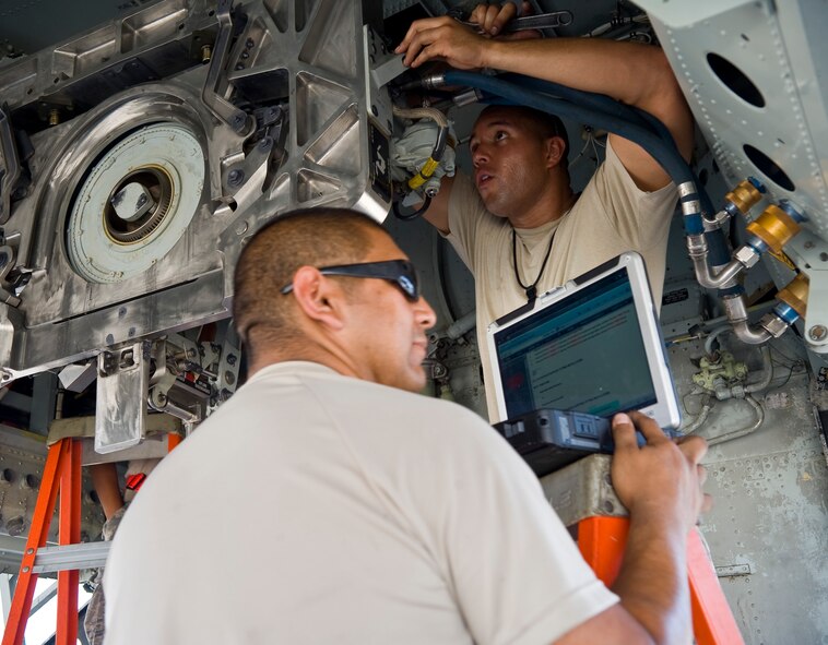 Airman 1st Class Jonathan Agudelo, 20th Aircraft Maintenance Unit load team member, installs a yoke in the bomb bay of a B-52H Stratofortress while Senior Airman Robert Cavazos, 20 AMU load team member, consults the technical order on the flightline at Barksdale Air Force Base, La., Aug. 9. When installed, the yokes are used to mount strategic weapons inside the B-52. (U.S. Air Force photo/Staff Sgt. Chad Warren)(RELEASED)