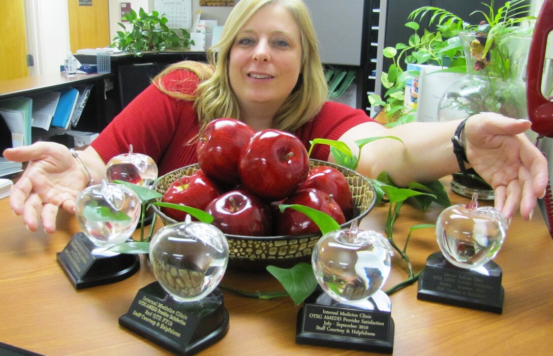 Tamara D. Parker of the McDonald Army Health Center's Internal Medicine clinic displays the team's batch of crystal apple awards received through the health center's Army Provider Level Satisfaction Survey recognition program at Fort Eustis, Va., July 22, 2012. The program recognizes the health center's clinics quarterly on their exemplary behaviors, resulting in on-the-spot recognition for personnel. (U.S. Army photo by Marlon J. Martin/Released)