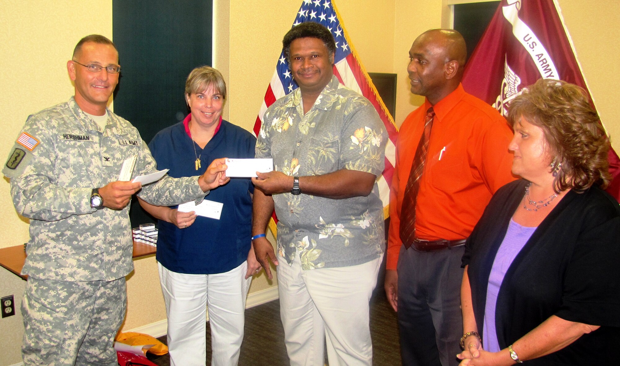 During a recent Army Provider Level Satisfaction Survey award ceremony, Col. Michael E. Hershman, McDonald Army Health Center commander, presented an "on the spot" cash award in the amount of $250 to medical assistant Albert Durant inside the health center at Fort Eustis, Va., July 27, 2012. Hershman also awarded Beverly A. Ritz, a medical assistant in the Eye, Ears, Nose and Throat Clinic; Theodore Eppes, a Patient Safety representative; and Patricia Case, a medical assistant in Internal Medicine, for their excellent customer service support. (U.S. Army photo by Marlon J. Martin/Released)