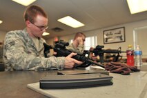 MINOT AIR FORCE BASE, N.D. -- Senior Airman Ian Hart, 5th Maintenance Squadron, gets familiar with an M-4 rifle during combat arms training and maintenance here, Aug. 1. The basic marksman skill training includes intensive weapons training, target acquisition, threat discrimination, multiple-threat engagement and surviving weapon malfunction and stoppages. (U.S. Air Force photo/Senior Airman Brittany Y. Auld)