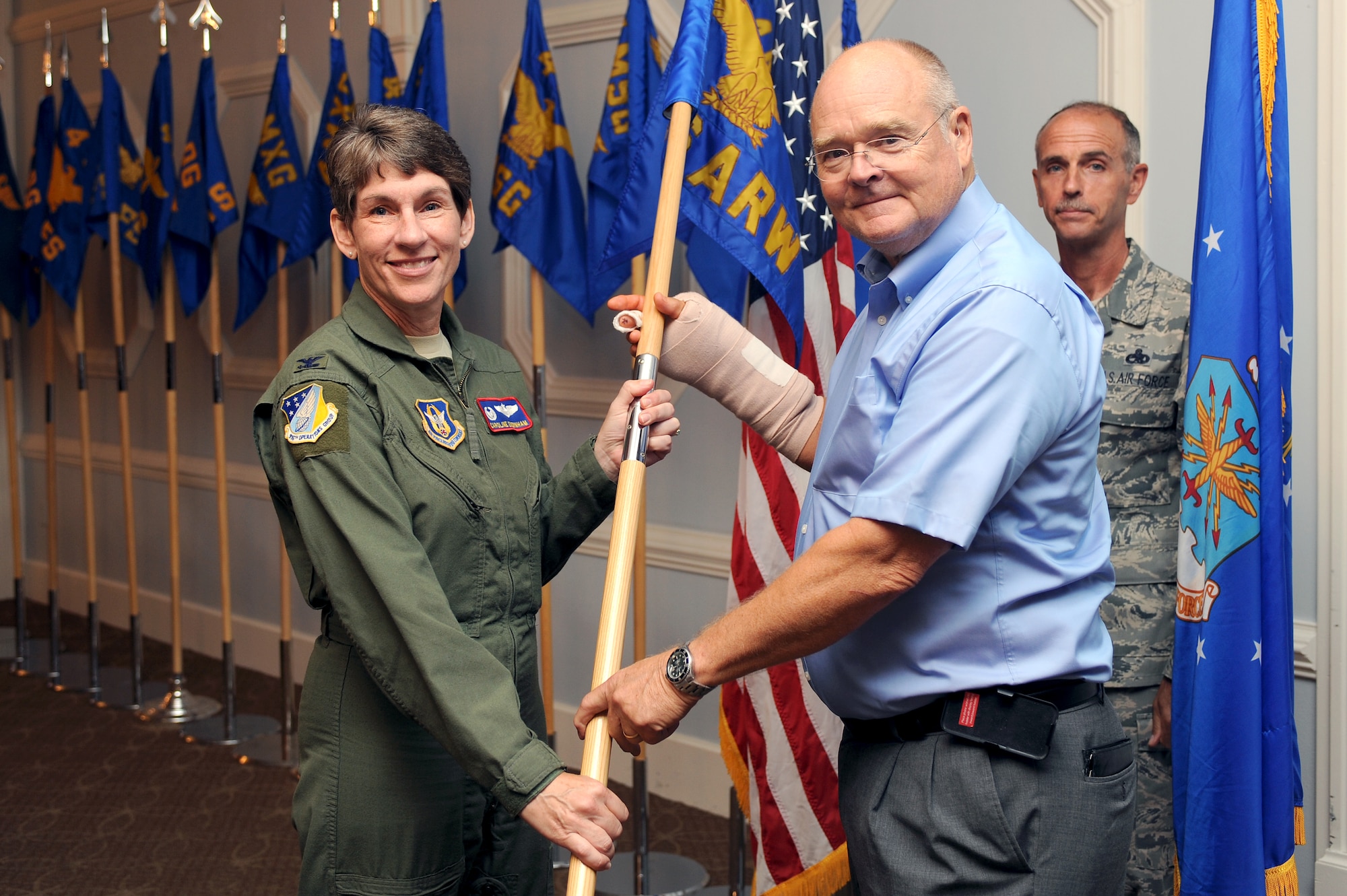U.S. Air Force Col. Caroline Evernham, 916th Operations Group commander, passes a guidon to Dr. Mike Gooden, Military Affairs Committee member, during an honorary commanders' induction ceremony at Eagle’s Landing on Seymour Johnson Air Force Base, N.C., Aug. 7, 2012. During the ceremony, leaders from the Wayne County and Goldsboro communities were inducted to work side-by-side with the base’s senior leadership to improve the base and surrounding communities.  (U.S. Air Force photo/Airman 1st Class John Nieves Camacho/Released)