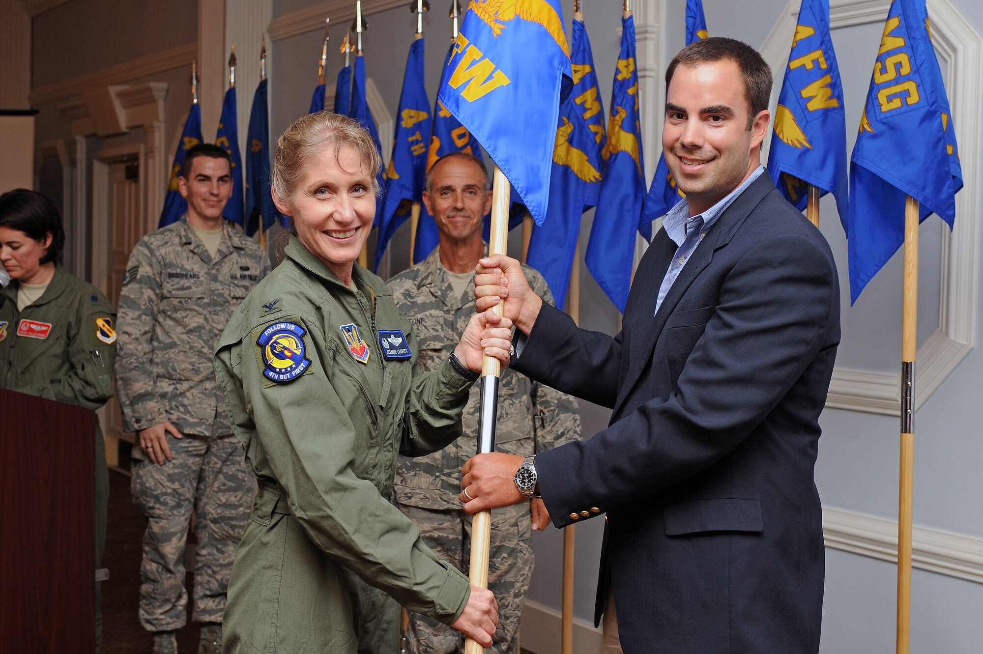 U.S. Air Force Col. Jeannie Leavitt, 4th Fighter Wing commander, passes a guidon to Ben Seegars, chief operating officer of Seegars Fence Company, during an honorary commanders' induction ceremony at Eagle’s Landing on Seymour Johnson Air Force Base, N.C., Aug. 7, 2012. During the ceremony, leaders from the Wayne County and Goldsboro communities were inducted to work side-by-side with the base’s senior leadership to improve the base and surrounding communities. (U.S. Air Force photo/Airman 1st Class John Nieves Camacho/Released)