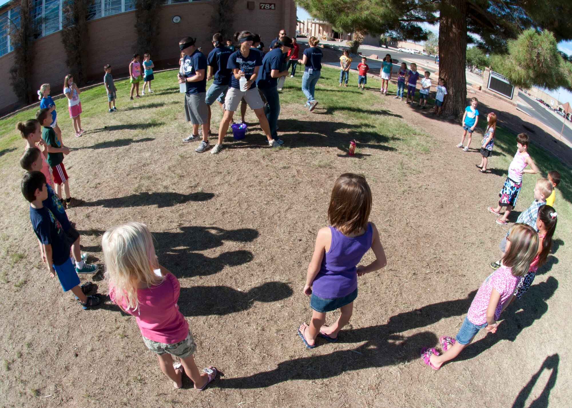 Children participating in the Holloman Air Force Base, N.M., Vacation Bible School make a circle around their group leaders as they prepare to play a water game at the base Chapel Aug. 3. During the game, the children tried to receive water balloons without getting sprayed by water from their group leaders. The VBS program, a week-long event sponsored by the wing’s chapel staff, is offered to all children of Team Holloman. During this year’s event, themed “Everything is Possible with God,” participants created different crafts, played various games, and read bible stories. (U.S. Air Force photo by Airman Leah Ferrante/Released)
