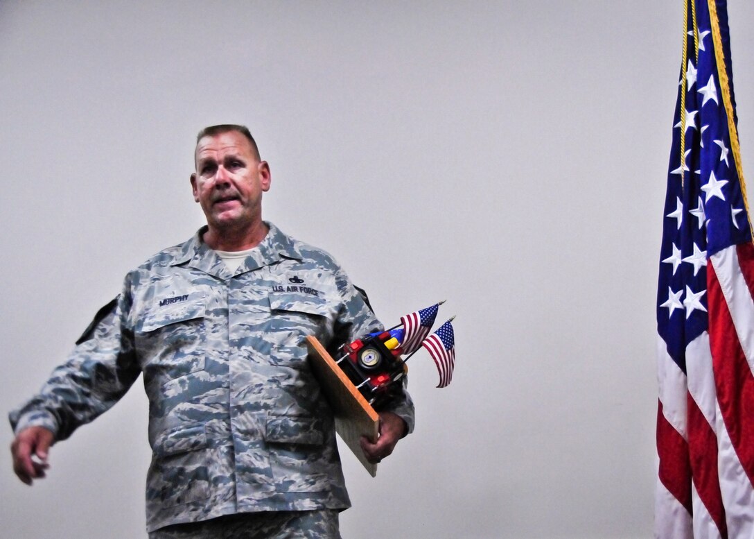 Chief Master Sgt. Kevin Murphy, 919th Maintenance Group, guards his newly acquired prop as the 919th Special Operations Wing's newest "Jeep Chief" during his chief induction ceremony at Duke Field Aug. 4.  Following Air Force tradition, Murphy must keep the Jeep model with him at all times until the next new chief is similarly promoted. (U.S. Air Force photo/Tech. Sgt. Jasmin Taylor)