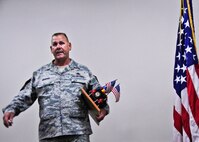 Chief Master Sgt. Kevin Murphy, 919th Maintenance Group, guards his newly acquired prop as the 919th Special Operations Wing's newest "Jeep Chief" during his chief induction ceremony at Duke Field Aug. 4.  Following Air Force tradition, Murphy must keep the Jeep model with him at all times until the next new chief is similarly promoted. (U.S. Air Force photo/Tech. Sgt. Jasmin Taylor)