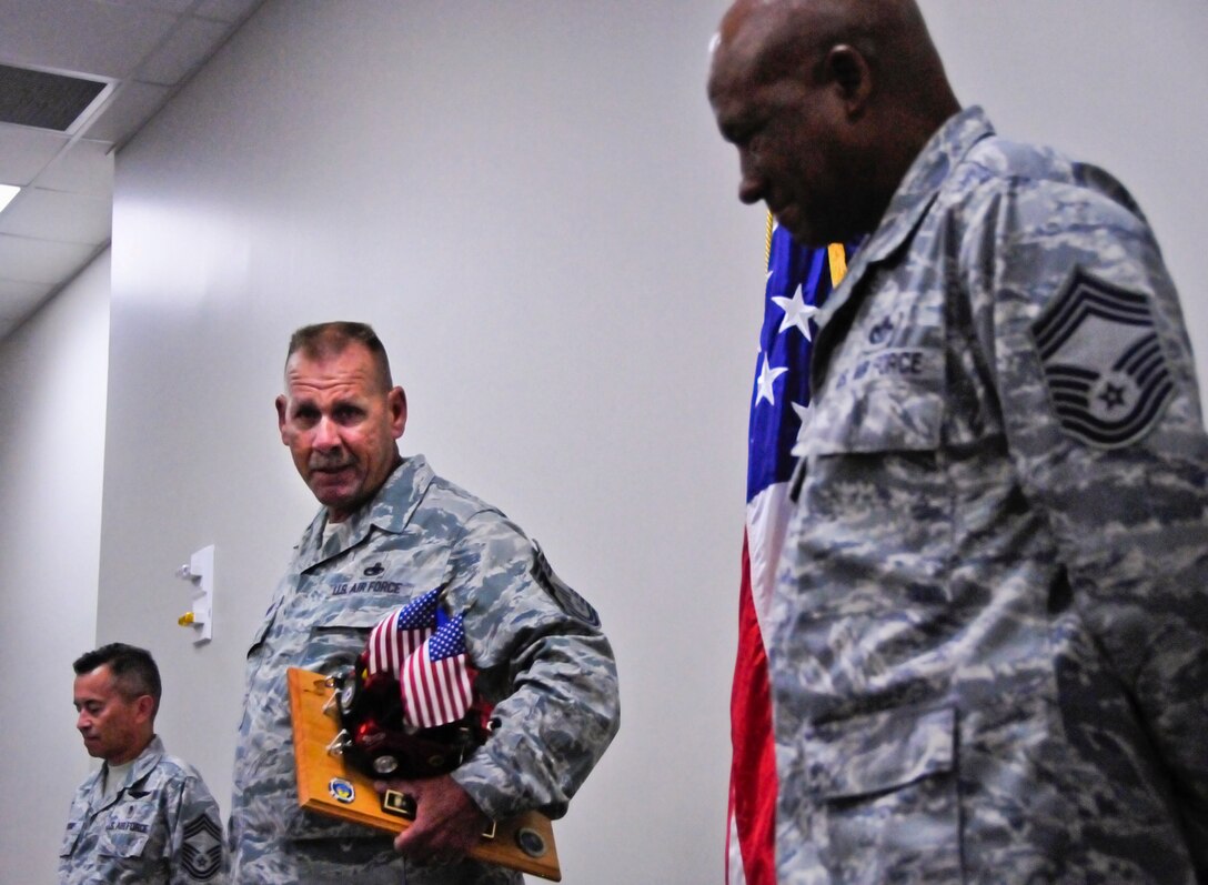 Chief Master Sgt. Kevin Murphy, 919th Maintenance Group, guards his newly acquired prop as the 919th Special Operations Wing's newest "Jeep Chief" during his chief induction ceremony at Duke Field Aug. 4.  Following Air Force tradition, Murphy must keep the Jeep model with him at all times until the next new chief is similarly promoted. (U.S. Air Force photo/Tech. Sgt. Jasmin Taylor)