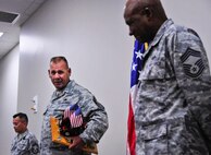 Chief Master Sgt. Kevin Murphy, 919th Maintenance Group, guards his newly acquired prop as the 919th Special Operations Wing's newest "Jeep Chief" during his chief induction ceremony at Duke Field Aug. 4.  Following Air Force tradition, Murphy must keep the Jeep model with him at all times until the next new chief is similarly promoted. (U.S. Air Force photo/Tech. Sgt. Jasmin Taylor)
