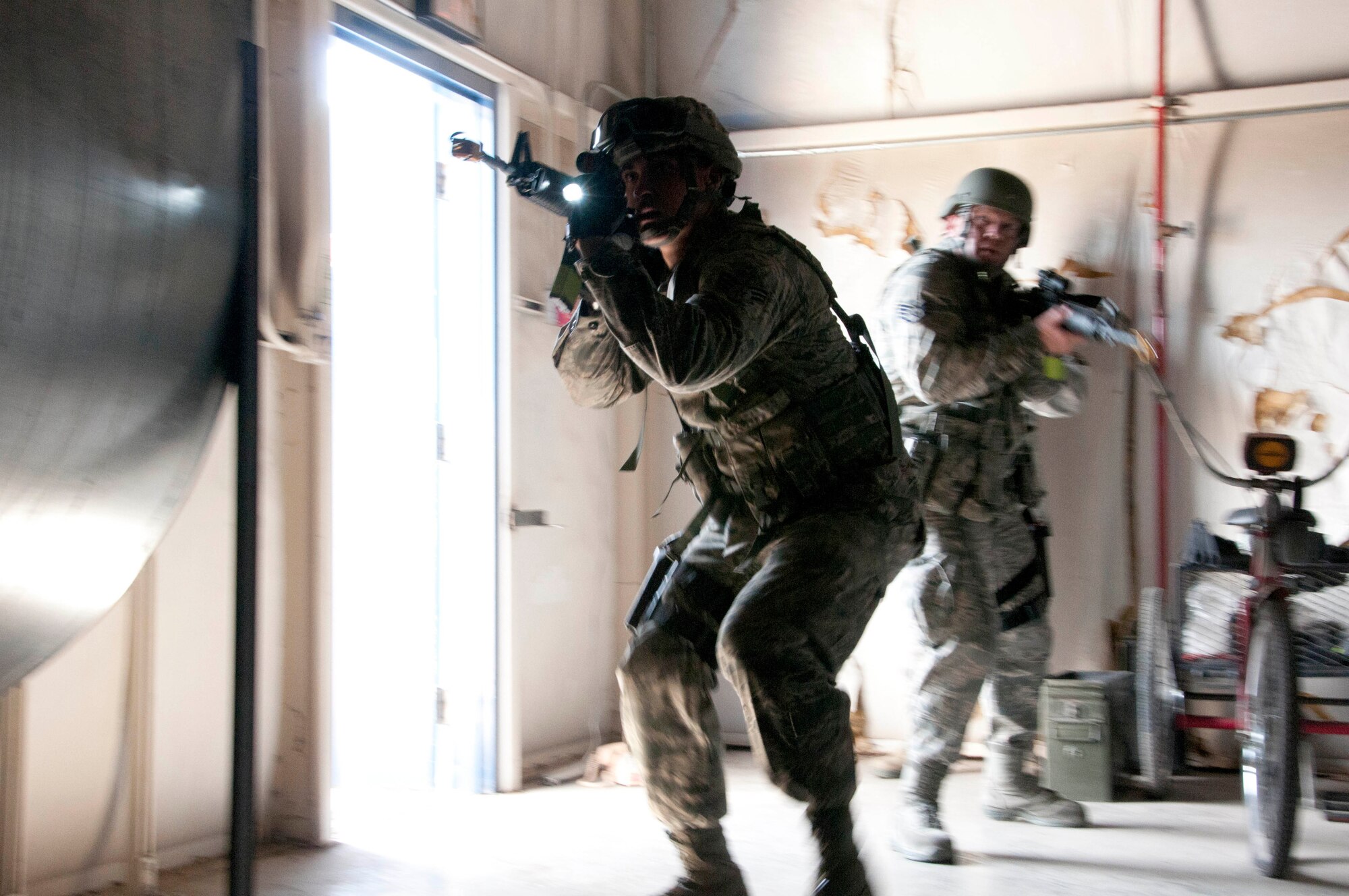 Senior Airman Samuel Alanis (left) and Staff Sgt. Brad Guzman seek out a simulated active shooter during an exercise at the 162nd Fighter Wing in Tucson Ariz. Both troops are from the Security Forces Squadron, whose members were being trained and evaluated in response to a simulated active shooter.  (U.S. Air Force photo/Master Sgt. David Neve)