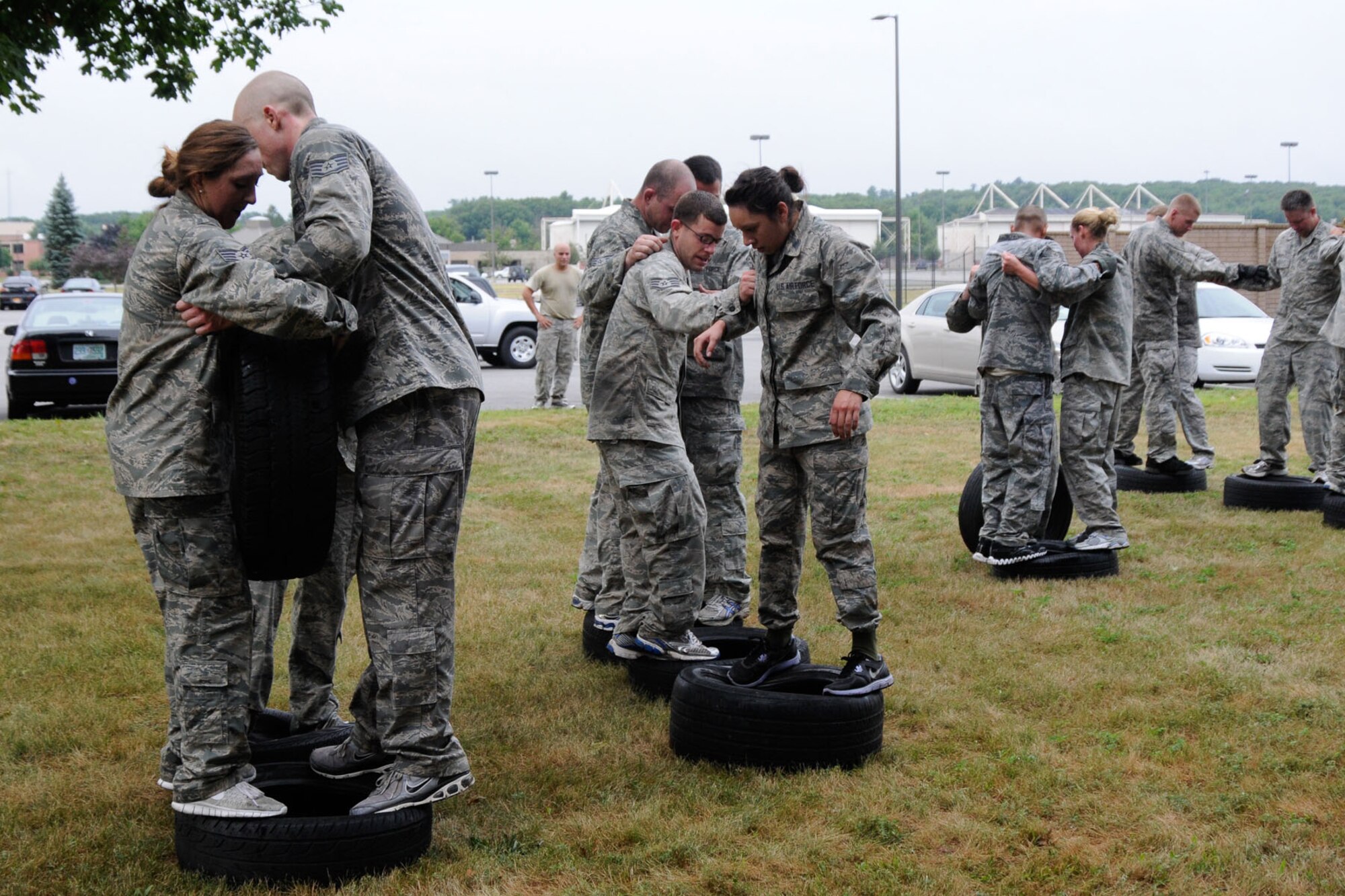 HANSCOM AIR FORCE BASE, Mass. – Four different teams work together to move across a field using tires during a Warrior Day activity Aug. 1. In addition to participating in warrior physical training in the morning, teams took part in a mentoring session during lunch. (U.S. Air Force photo by Linda LaBonte Britt) 
