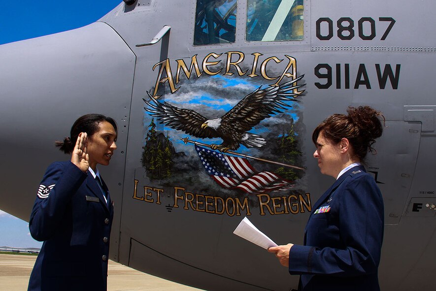 Capt. Tina M. Hannasch, Operations Support Squadron executive officer, reenlists Tech. Sgt. Aazita Afshari for an additional six years in front of a 911th Airlift Wing C-130 Hercules on the Pittsburgh International Airport flightline, Aug. 7, 2012. Afshari continues her traditional reservist duties as a knowledge operations specialist with the 911th AW Communication Squadron. Besides remaining active in the Air Force Reserve, Afshari works as a civilian secretary at the Operations Group commander and serves as an active member of the base Honor Guard. (U.S. Air Force photo by Senior Airman Justyne Obeldobel/Released)