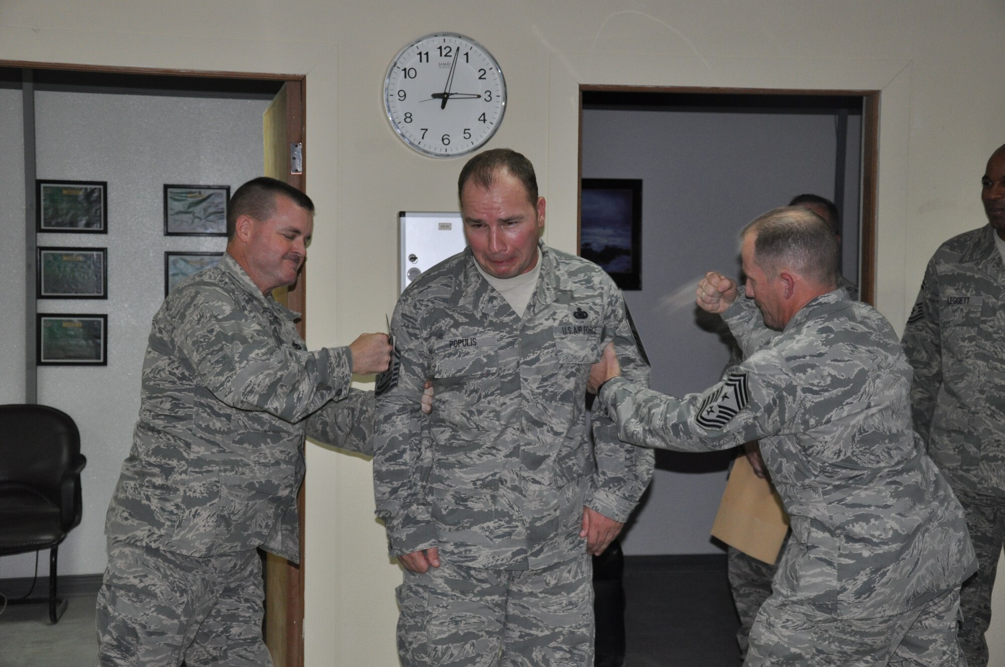 SOUTHWEST ASIA - Colonel Joseph Martin and Chief Master Sgt. Dennis Daubert "tack" chief stripes on Senior Master Sgt. James Populis to recognize his promotion to the rank of chief master sergeant here Aug. 9. The chief-select from the 386th Expeditionary Logistics Readiness Squadron was promoted through the supplemental promotion system. Martin is the 386th Expeditionary Mission Support Group commander and Daubert is the 386th Air Expeditionary Wing command chief master sergeant. (U.S. Air Force photo/Master Sgt. Kristina Barrett)