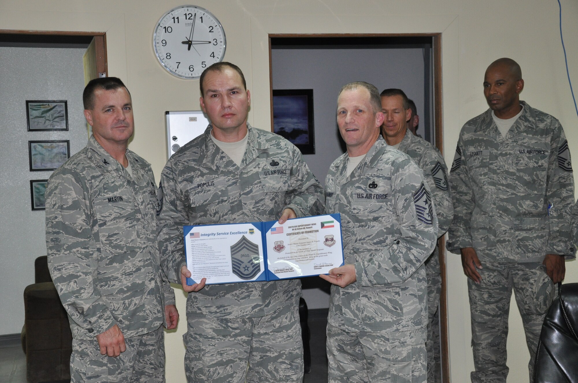 SOUTHWEST ASIA - Colonel Joseph Martin and Chief Master Sgt. Dennis Daubert recognize the promotion selection of Senior Master Sgt. James Populis to the rank of chief master sergeant here Aug. 9. The chief-select from the 386th Expeditionary Logistics Readiness Squadron was promoted through the supplemental promotion system. Martin is the 386th Expeditionary Mission Support Group commander and Daubert is the 386th Air Expeditionary Wing command chief master sergeant. (U.S. Air Force photo/Master Sgt. Kristina Barrett)