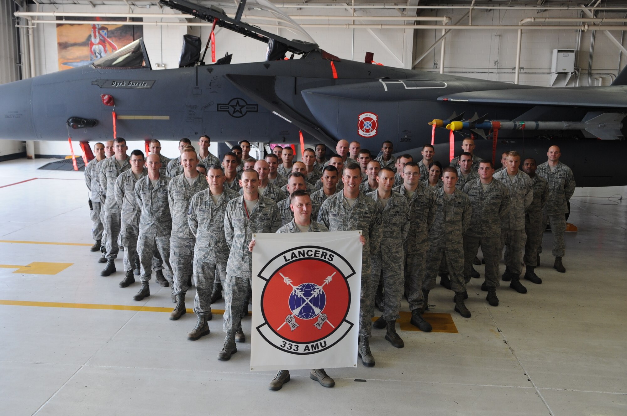 U.S. Air Force Airmen from the 333rd Aircraft Maintenance Unit pose for a group photo in front of an F-15E Strike Eagle on Seymour Johnson Air Force Base, N.C., Aug. 2, 2012. The Airmen came together to prepare an aircraft in honor of Dyrk Burcie, a 4-year old living with terminal, stage four, pediatric liver cancer. (U.S. Air Force photo/Airman 1st Class Aubrey Robinson/Released)