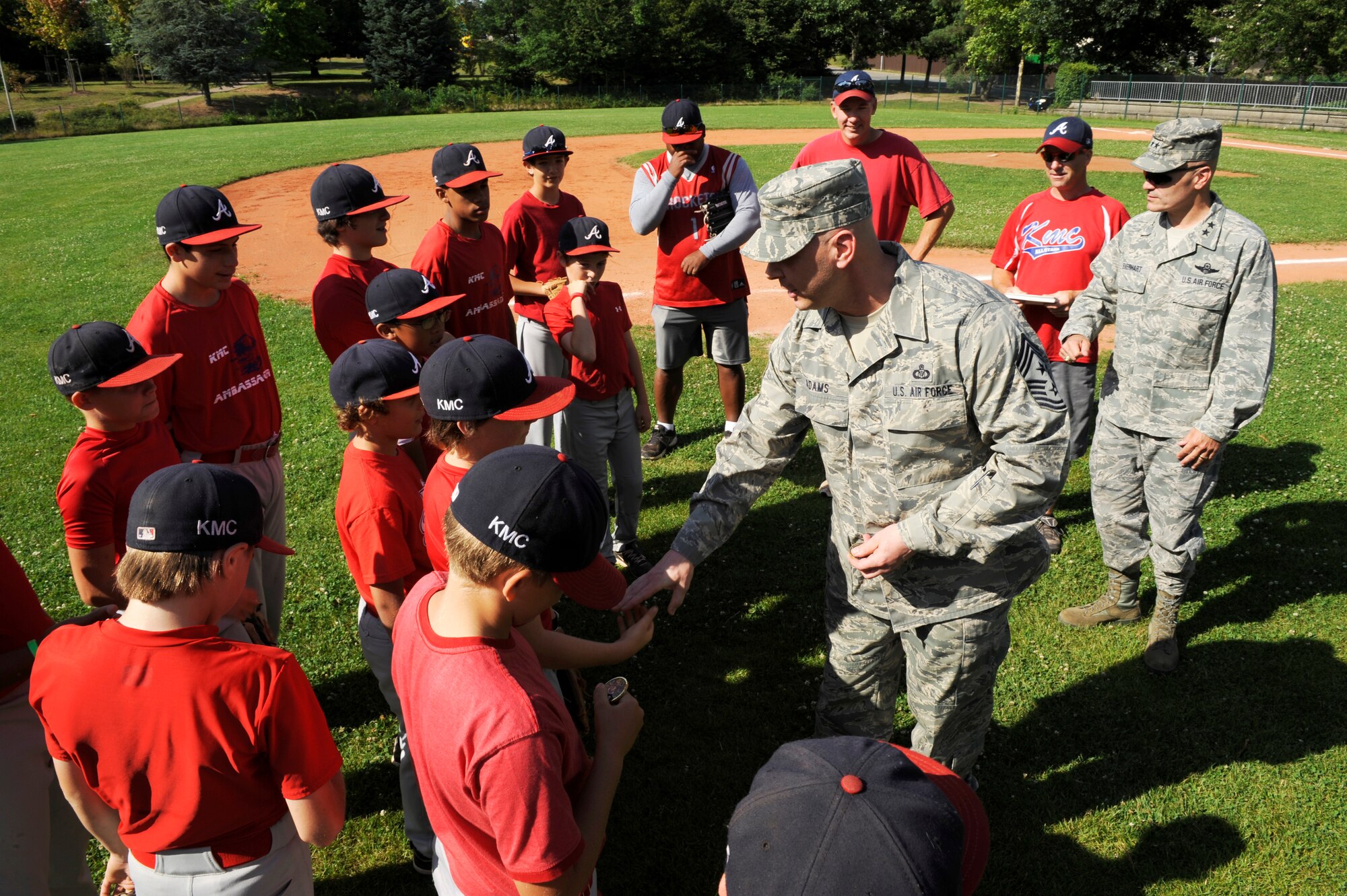 Chief Master Sgt. Craig A. Adams, 3rd Air Force command chief, and Maj. Gen. Carlton D. Everhart II, 3rd AF vice commander, greet and coin athletes from the KMC all stars before practice at Donnelly Park on Ramstein Air Base, Aug. 7, 2011. For the third time in four years, the KMC all stars advanced to the Little League World Series beginning Aug. 16 in Williamsport, Penn. (U.S. Air force photo/ Senior Airman Aaron-Forrest Wainwright)