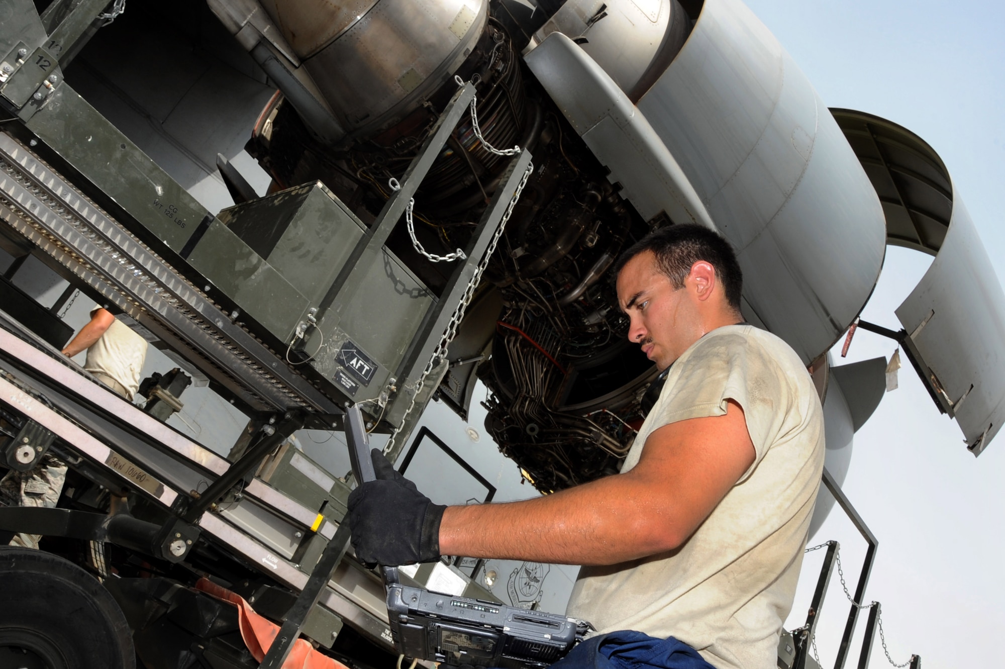 U.S. Air Force Staff Sgt. Aaron Bingham, 8th Expeditionary Air Mobility Squadron aerospace propulsion craftsman, checks the technical data before attaching the engine removal/installation cradle to the C-17 Globemaster III engine three in Southwest Asia, August 4, 2012. Most engine changes are done within 48 hours in a controlled environment inside an aircraft hangar, but the ?Ocho? team finished in 34 hours and saved $120,000 by doing the repairs downrange at the 379th Air Expeditionary Wing. Bingham is deployed from Joint Base Lewis-McChord, Wash. (U.S. Air Force photo/Staff Sgt. Sheila deVera)