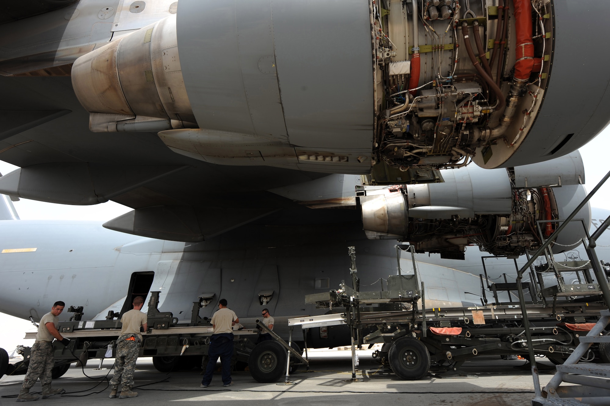 Members from the 8th Expeditionary Air Mobility Squadron worked together to replace a C-17 Globemaster III engine in Southwest Asia, August 4, 2012. Most engine changes are done within 48 hours in a controlled environment inside an aircraft hangar, but the ?Ocho? team finished in 34 hours and saved $120,000 by doing the repairs downrange at the 379th Air Expeditionary Wing. (U.S. Air Force photo/Staff Sgt. Sheila deVera)