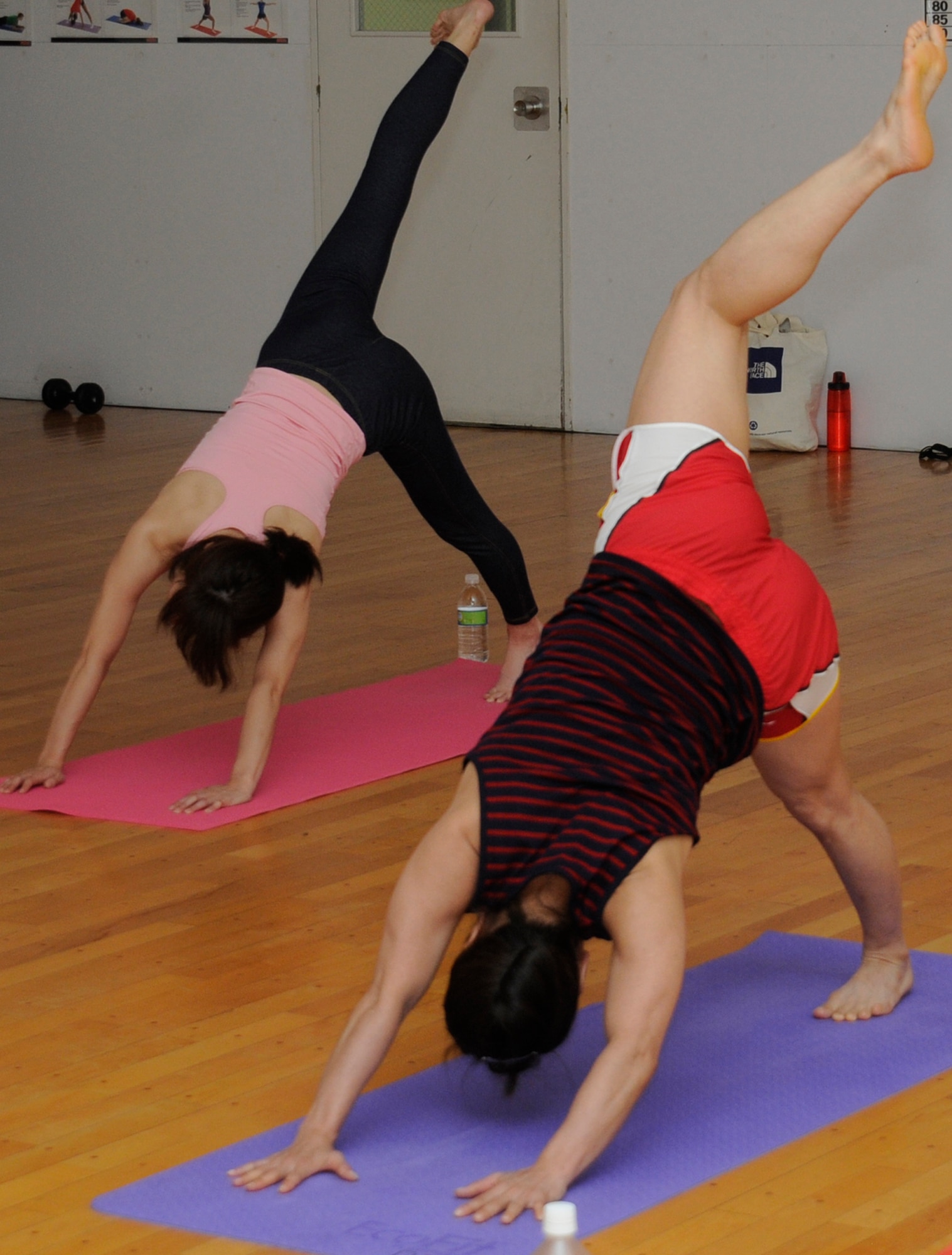 Yoga class participants pose in the downward dog position at Misawa Air Base, Japan, Aug. 9, 2012. Yoga is one of many fitness classes offered at the Potter Fitness Center. Classes available include kickboxing, spin, intro to cross fit, Zumba and five types of yoga. (U.S. Air Force photo by Airman 1st Class Zachary Kee/Released)