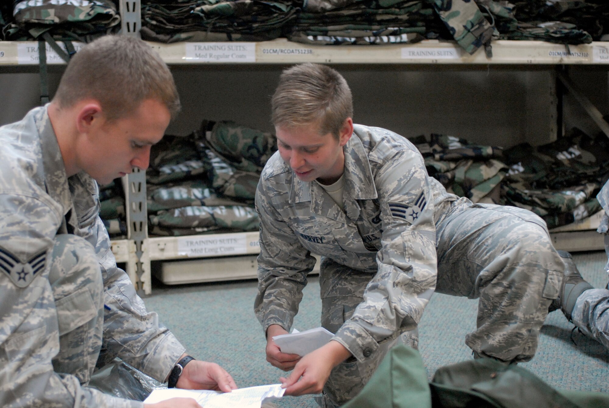 Senior Airman Jennifer Harvey (right), 51st Logistics Readiness Squadron Individual Protective Equipment journeyman, assists Senior Airman Douglas Stubblebine, 51st LRS Travel Management Office, with his IPE inventory at Osan Air Base, Republic of Korea, Aug. 9, 2012. Airmen receive one bag containing real-world equipment, and another with training over garments, boots, vests, gas masks, helmets and gloves. (U.S. Air Force photo/Airman 1st Class Alexis Siekert)