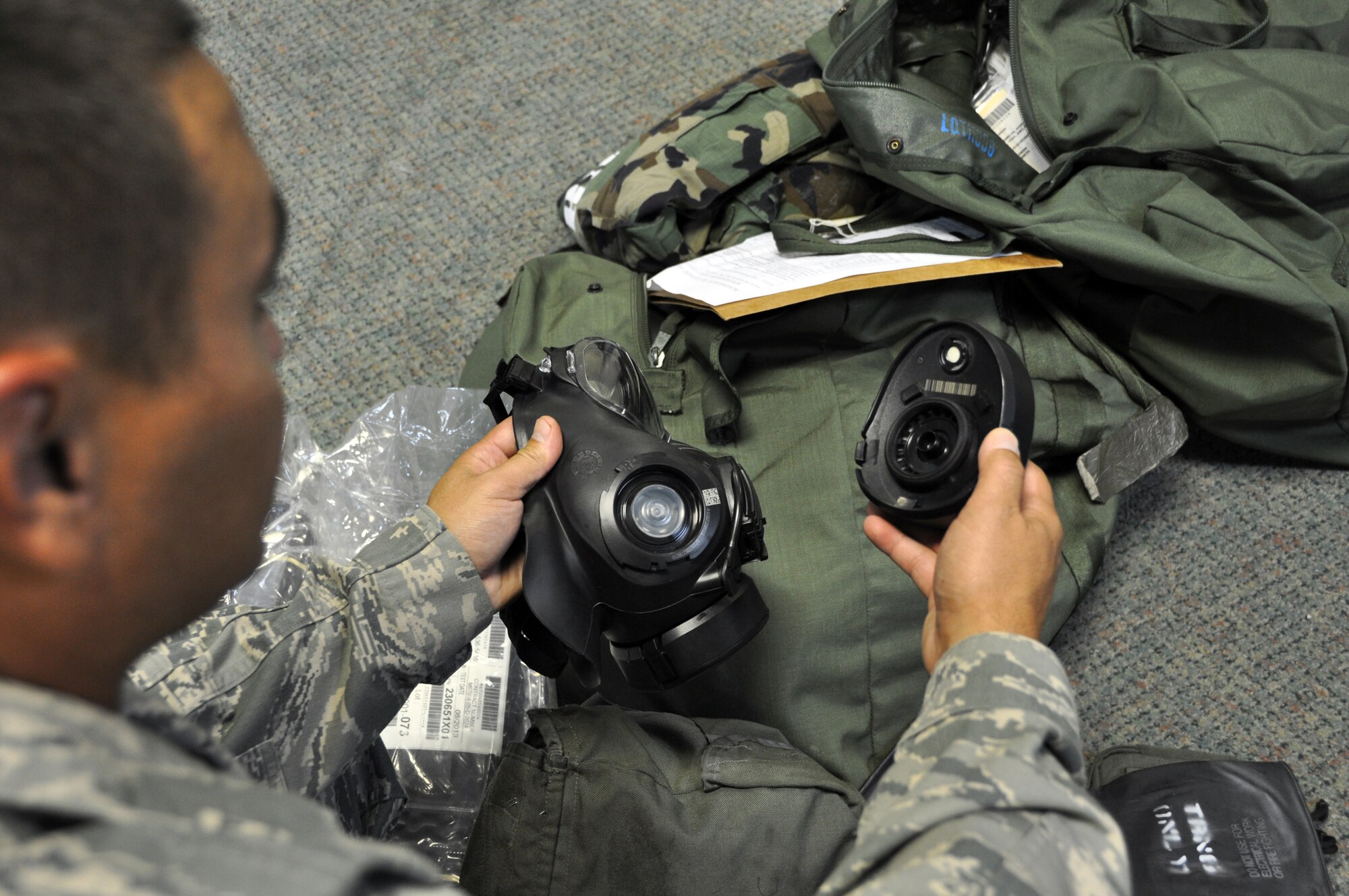 A new member of Team Osan inspects his gas mask filter at the 51st Logistics Readiness Squadron Individual Protective Equipment facility during combat in-processing at Osan Air Base, Republic of Korea, Aug. 7, 2012. IPE is the minimum personal clothing and equipment needed to protect wearers from most chemical, biological, radiological, nuclear and high yield hazards. (U.S. Air Force photo/Airman 1st Class Alexis Siekert)