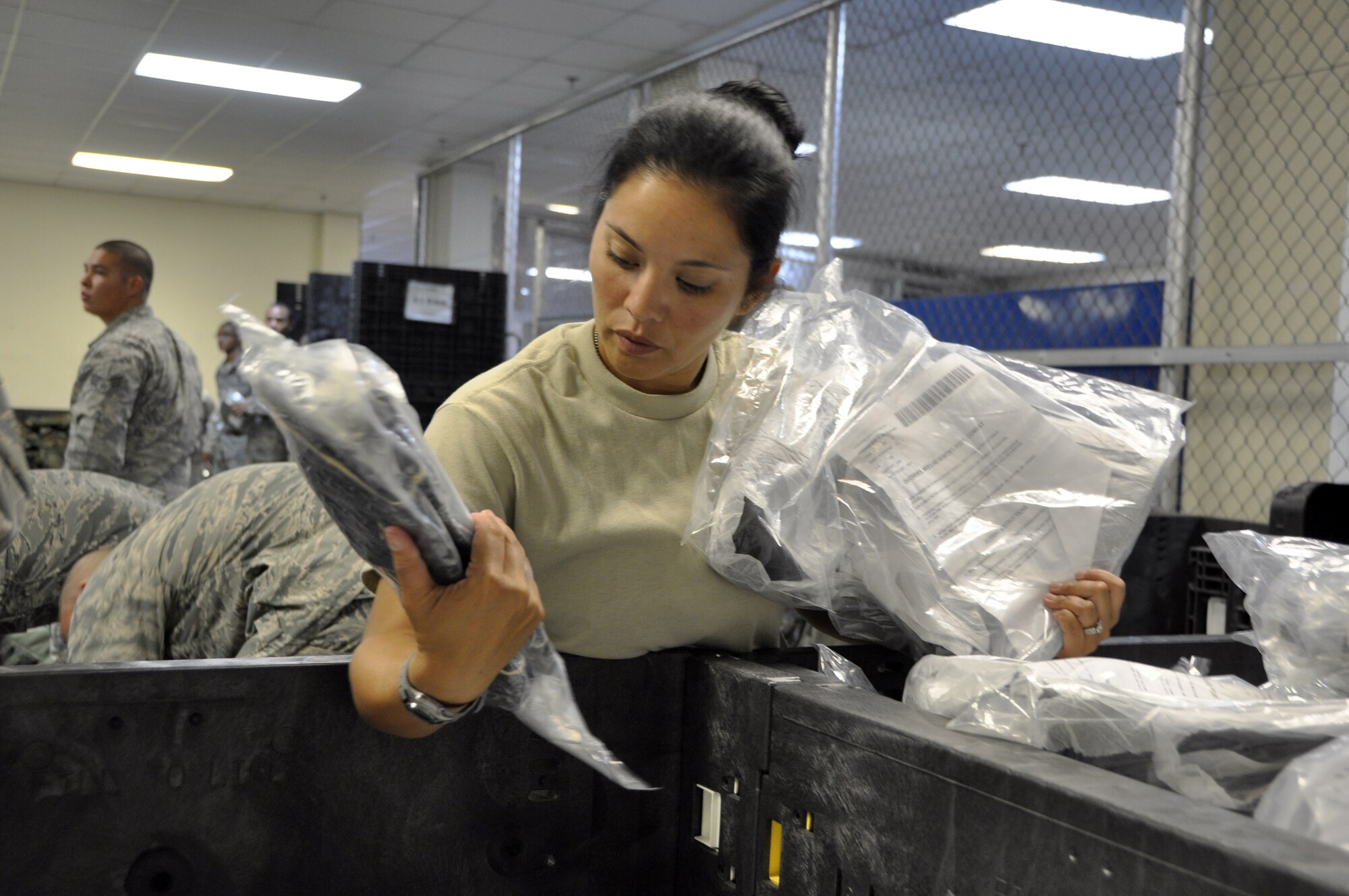 Tech. Sgt. Mariya Cavazos-Munguia, 51st Comptroller Squadron customer service NCO in charge, selects a pair of real-world over boots for her Individual Protective Equipment bag at Osan Air Base, Republic of Korea, Aug. 7, 2012. The 51st Logistics Readiness Squadron IPE facility issues gear to all Osan service memebers during their first week of combat in-processing. (U.S. Air Force photo/Airman 1st Class Alexis Siekert)
