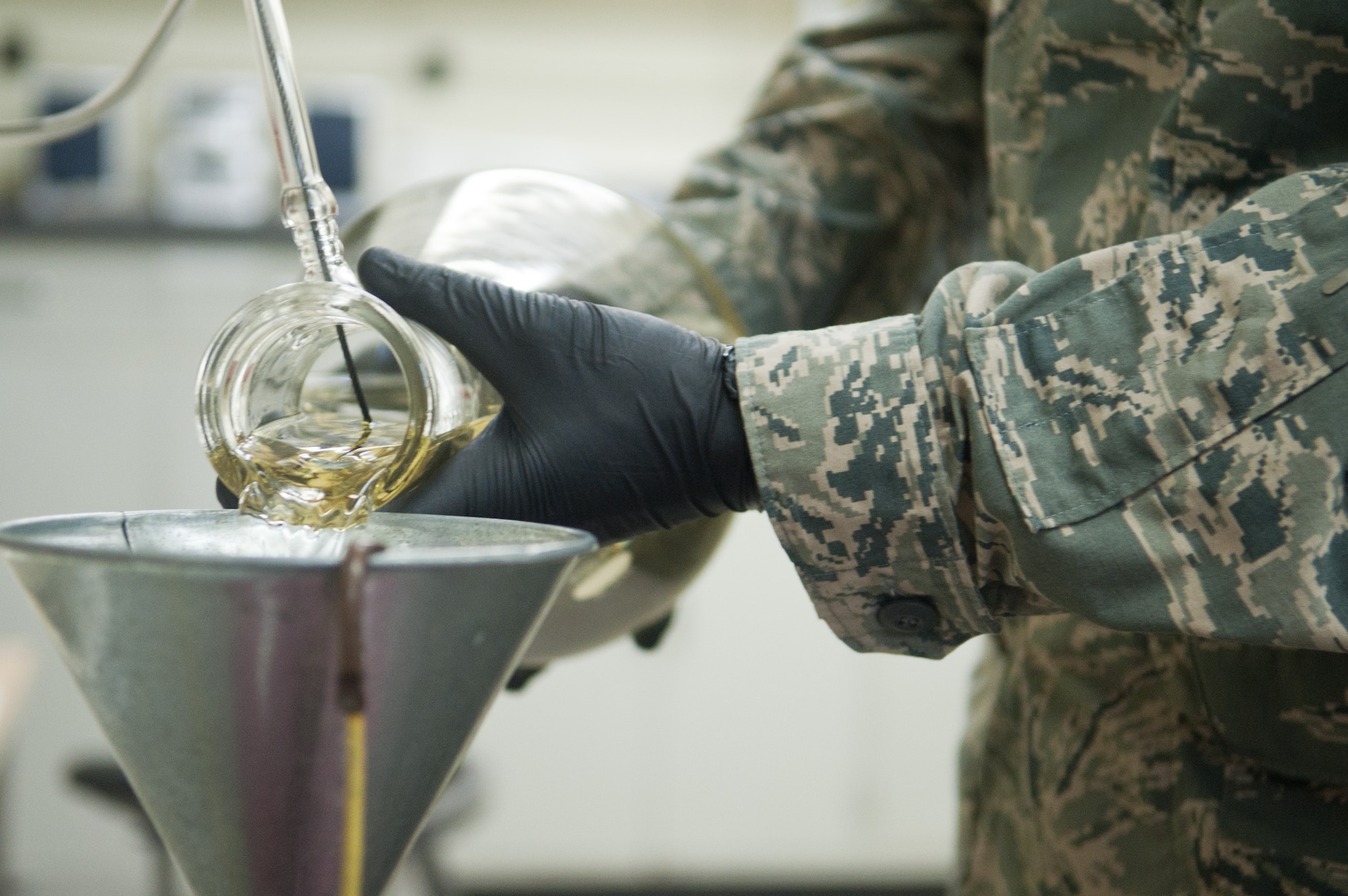 YOKOTA AIR BASE, Japan -- Staff Sgt. Jeremiah Palmer, 374th Logistics Readiness Squadron Petroleum, Oils and Lubricants fuels laboratory NCO in charge, pours JP-8 aircraft fuel into a container through a funnel at Yokota Air Base, Japan, on Aug. 7, 2012. Aircraft fuel is the most frequently used fuel by the 374 LRS POL shop. (U.S. Air Force photo by Airman 1st Class John D. Partlow)
