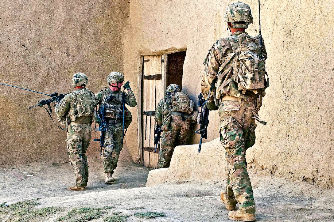 U.S. Army Sgt. 1st. Class Alan Sutton, 2nd from left, radios in an update as fellow paratroopers clear a compound during a foot patrol in Afghanistan's Ghazni province, Aug. 1, 2012. Sutton, a platoon leader, is assigned to the 82nd Airborne Division's Company A, 1st Battalion, 504th Parachute Infantry Regiment, 1st Brigade Combat Team.