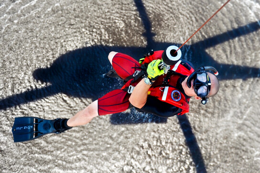 Coast Guard Petty Officer 1st Class Bret Fogle gets hoisted into an MH-60 Jayhawk helicopter near Coast Guard Air Station Elizabeth City, N.C., Aug. 3, 2012. Fogle, a rescue swimmer, is assigned to Coast Guard Air Station Elizabeth City, N.C. The crews conducted hoist training with cadets assigned to the Coast Guard Academy in New London, Conn., as part of their summer visit to the air station.