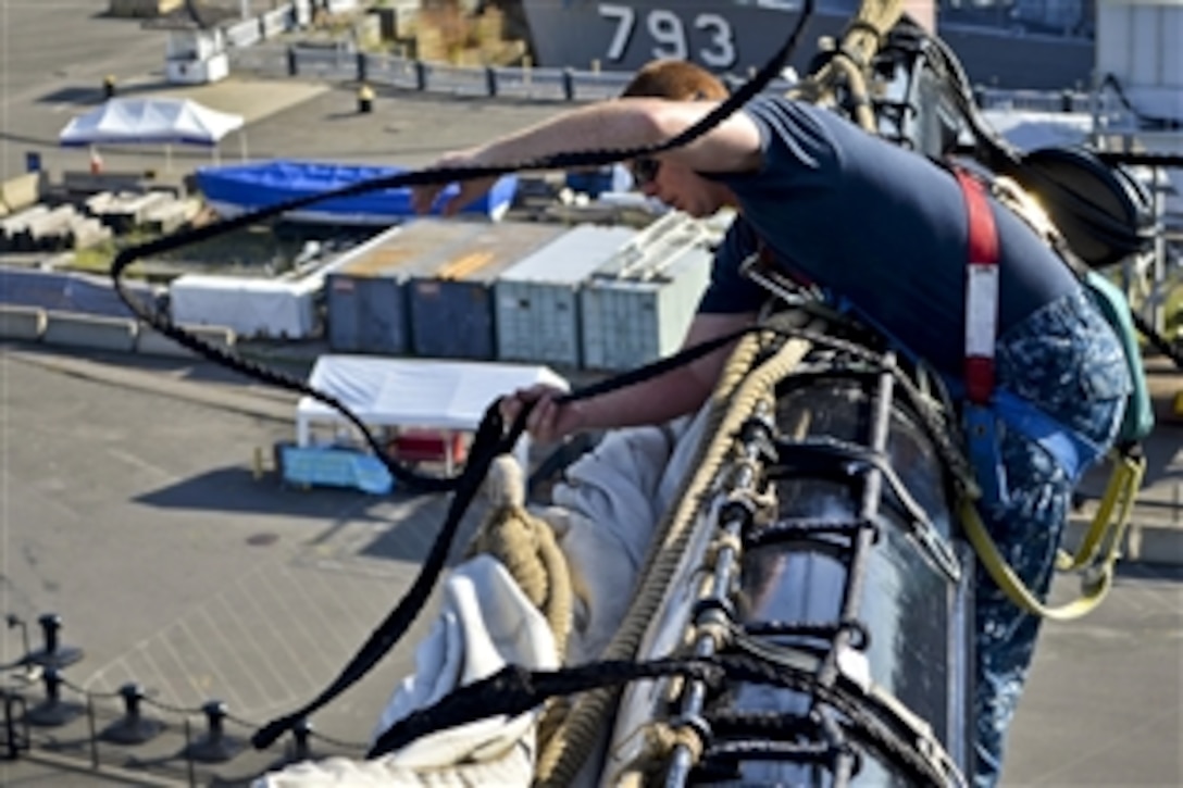 Navy Seaman William Gillaspie throws a gasket line attached to the USS Constitution's top sail over the yard on the main mast of the ship in Charlestown, Mass., Aug. 7, 2012. Constitution sailors routinely work to improve seamanship skills to prepare for sailing the ship for the bicentennial anniversary of the War of 1812.