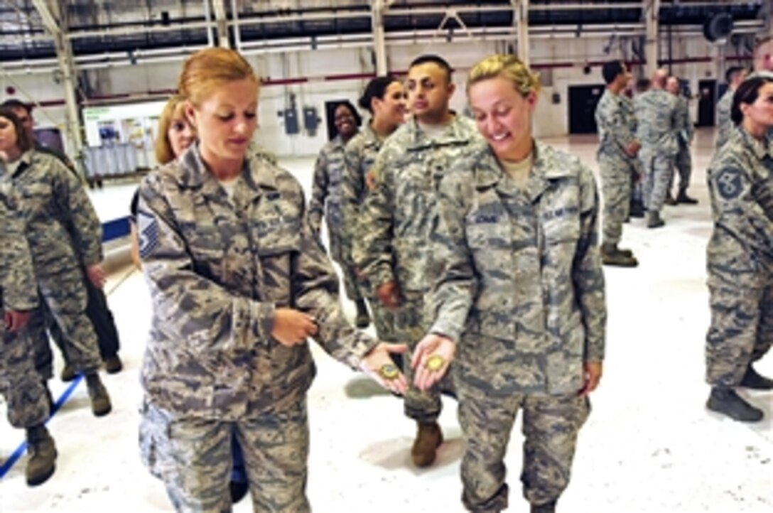 Air Force Master Sgt. Jessica King and Staff Sgt. Kara Schmidt hold commemorative coins they received from Defense Secretary Leon E. Panetta during his visit to Niagara Falls Air Reserve Station, N.Y., Aug. 9, 2012. King is the107th Remote Designee assigned to Force Support Squadron, and Schmidt is assigned to 107th Cyber Operations.