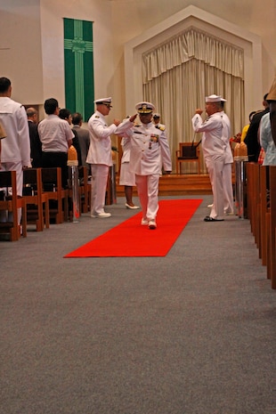 Robert M. Casey Medical and Dental Clinic sailors salute Cmdr. Cesar Odvina, outgoing Branch Health Clinic officer-in-charge, as the command personnel step off stage during the BHC change of charge ceremony at the Marine Memorial Chapel here Aug. 10, 2012. Odvina served three years aboard station as the BHC officer-in-charge and enjoyed working with his sailors and supporting the station residents.