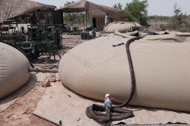 Marines with Marine Wing Support Squadron 374, based out of Twentynine Palms, Calif., work on a new water purification system at the Chocolate Mountains Aerial Gunnery Range in MCAS Yuma region, Aug. 9. The lightweight purification water recycling system uses 3,000 gallon collapsible tanks that pump and filter out clean water which allows Marines to better conserve resources.