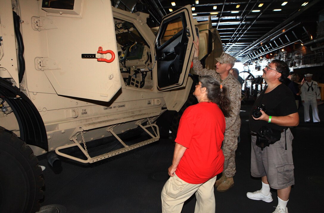 Lance Cpl. William Kresse, a combat cameraman with Combat Logistics Regiment 27, 2nd Marine Logistics Group, provides visitors to the USS San Antonio with a tour of the Mine Resistant Ambush Protected – All Terrain Vehicle during Maine’s 2012 Lobster Festival in Rockland, Aug 3. The vehicles on display with the ship provided a glimpse of the combined Marine-Navy capabilities during tours provided by Marines and the ship’s crew. (Photo by Lance Cpl. Paul Peterson)
