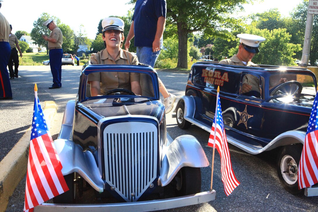 Pfc. Caitlin Wiggins, a landing support specialist with Combat Logistics Regiment 27, 2nd Marine Logistics Group, prepares to take a small replica of a 1935 “Paddy Wagon” for a spin while waiting to march in the parade for Maine’s 2012 Lobster Festival in Rockland, Aug. 4. Wiggins joined nearly 30 Marines from 2nd MLG and 100 sailors from the USS San Antonio at the head of the parade. (Photo by Lance Cpl. Paul Peterson)