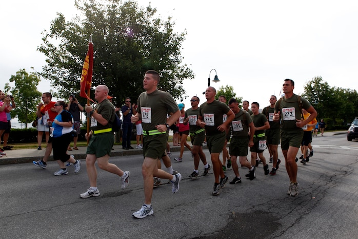A formation of Marines and sailors from 2nd Marine Logistics group launches into the first leg of a 10-kilometer race during Maine’s 2012 Lobster Festival in Rockland, Aug. 5. The servicemembers called cadence behind the nearly 330 other runners for the first two miles of the race before splitting up and racing each other to the finish line. (Photo by Lance Cpl. William M. Kresse)