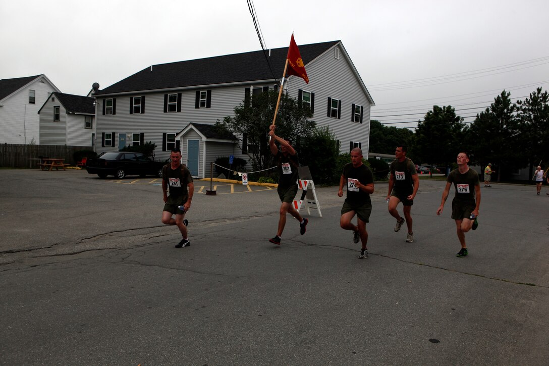 Marines from 2nd Marine Logistics Group carry their unit’s guidon across the finish line at the end of a 10-kilometer race during Maine’s 2012 Lobster Festival in Rockland, Aug. 5. Volunteers from the unit paid out of pocket to participate in the race, but they decided to run the first two miles as a group to demonstrate their unit’s cohesion. (Photo by Lance Cpl. William M. Kresse)