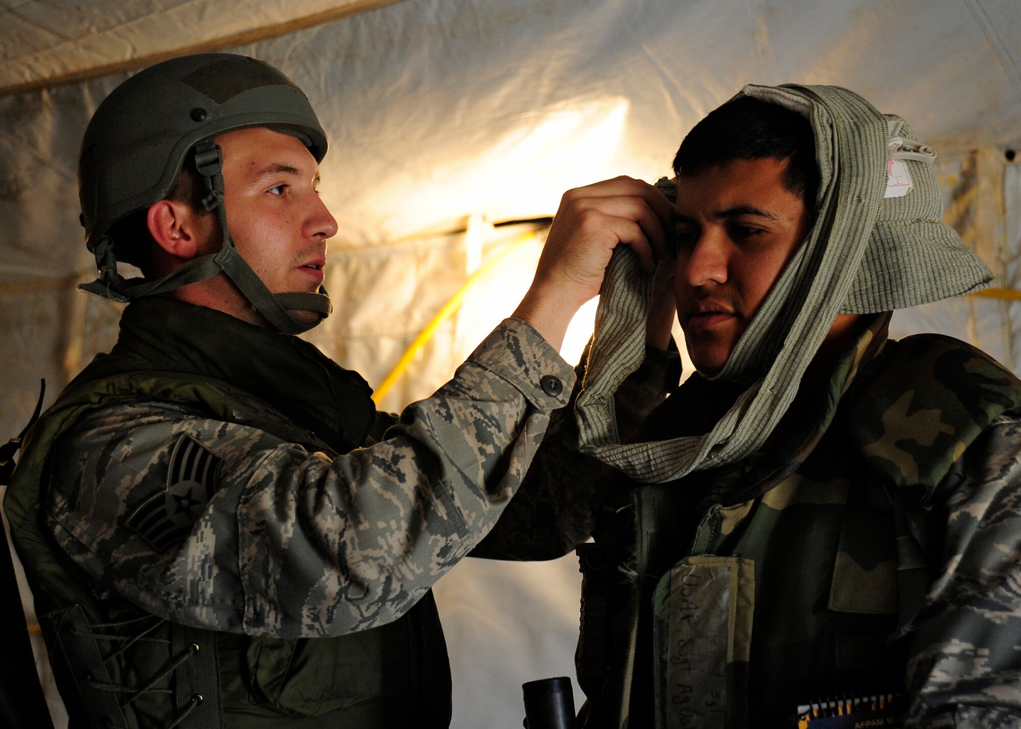 VANDENBERG AIR FORCE BASE, Calif. -- Staff Sgt. Steve Stanley , a 30th Logistic Readiness Squadron member, readies a head dressing on Staff Sgt. Augustin Aragon-Velazquez, a 30th Logistics Readiness Squadron member, as they prepare to evacuate Airmen wounded by a simulated mortar attack to the helicopter pickup area during the Northstar deployment exercise here Thursday, August 9, 2012. (U.S. Air Force photo/Michael Peterson)