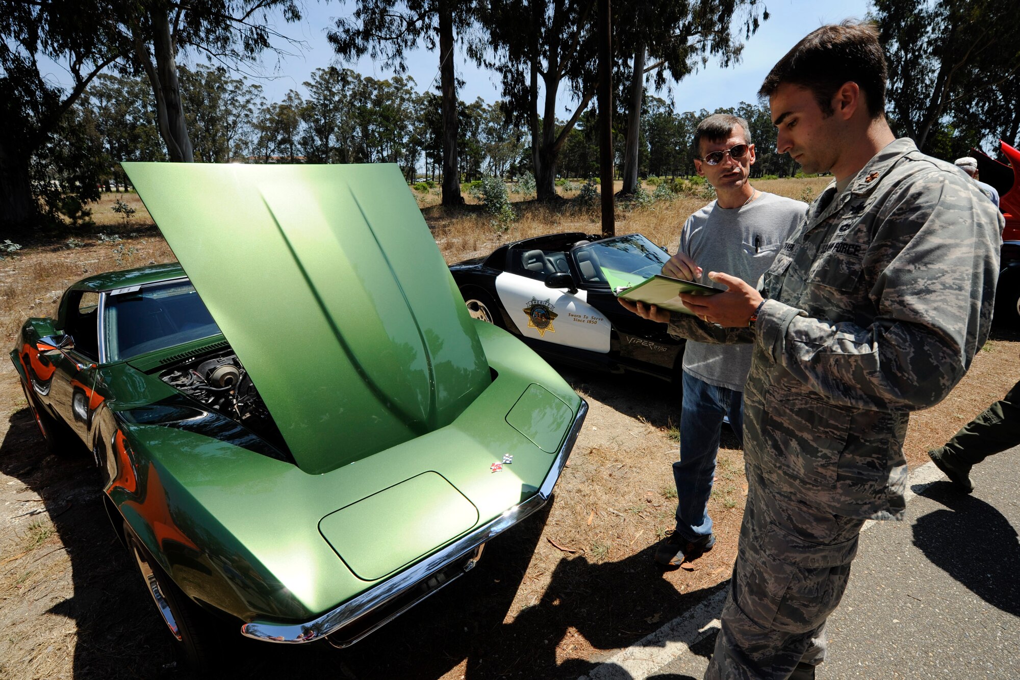 VANDENBERG AIR FORCE BASE, Calif. -- Maj. Jonathan Whitaker, a Joint Functional Component Command Space launch safety officer, talks to Chris Schmeltz, a retired military member, about his 1972 Corvette Stingray during the 24th Annual Texas Blowout event at Cocheo Park here Friday, August 10, 2012. The 392d Training Squadron hosted the event to help support families and bring camaraderie to the Vandenberg community by providing attractions including a bounce house, a car show, pin the tail on the donkey and a cow pie tossing competition.  (U.S. Air Force photo/Staff Sgt. Levi Riendeau)
