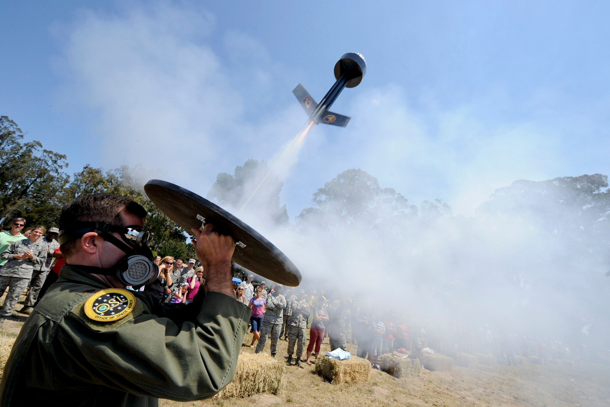 VANDENBERG AIR FORCE BASE, Calif. --Maj. Bryan Titus, the National Reconnaissance Office director of operations, launches a rocket carrying a cow pie during the 24th Annual Texas Blowout event at Cocheo Park here Friday, August 10, 2012. The 392d Training Squadron hosted the event to help support families and bring camaraderie to the Vandenberg community by providing attractions including a bounce house, a car show, pin the tail on the donkey and a cow pie tossing competition.  (U.S. Air Force photo/Staff Sgt. Levi Riendeau)