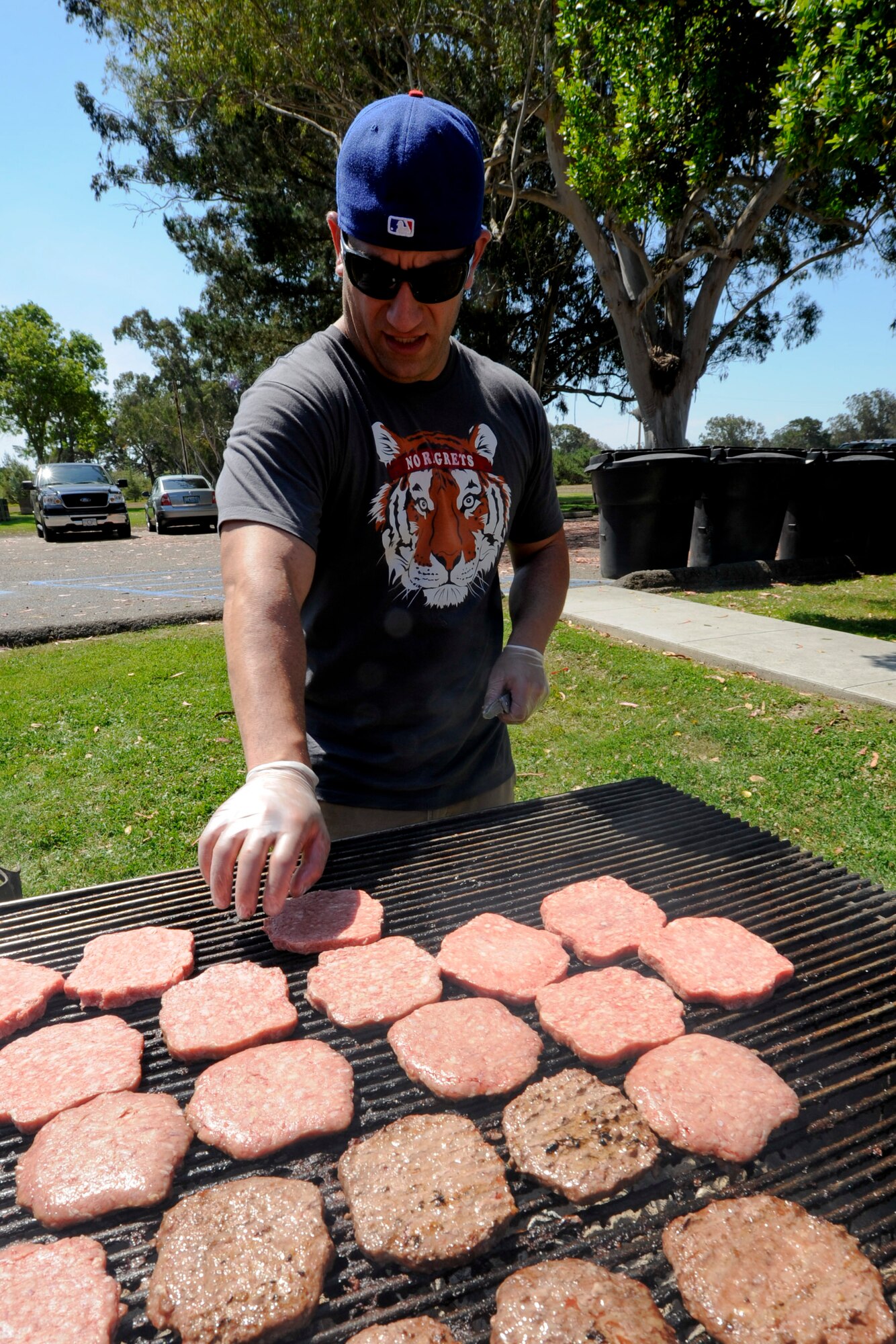 VANDENBERG AIR FORCE BASE, Calif. -- Capt. Max Bassman, a 532nd Training Squadron instructor, cooks burgers during the 24th Annual Texas Blowout event at Cocheo Park here Friday, August 10, 2012. The 392d Training Squadron hosted the event to help support families and bring camaraderie to the Vandenberg community by providing attractions including a bounce house, a car show, pin the tail on the donkey and a cow pie tossing competition.  (U.S. Air Force photo/Staff Sgt. Levi Riendeau)