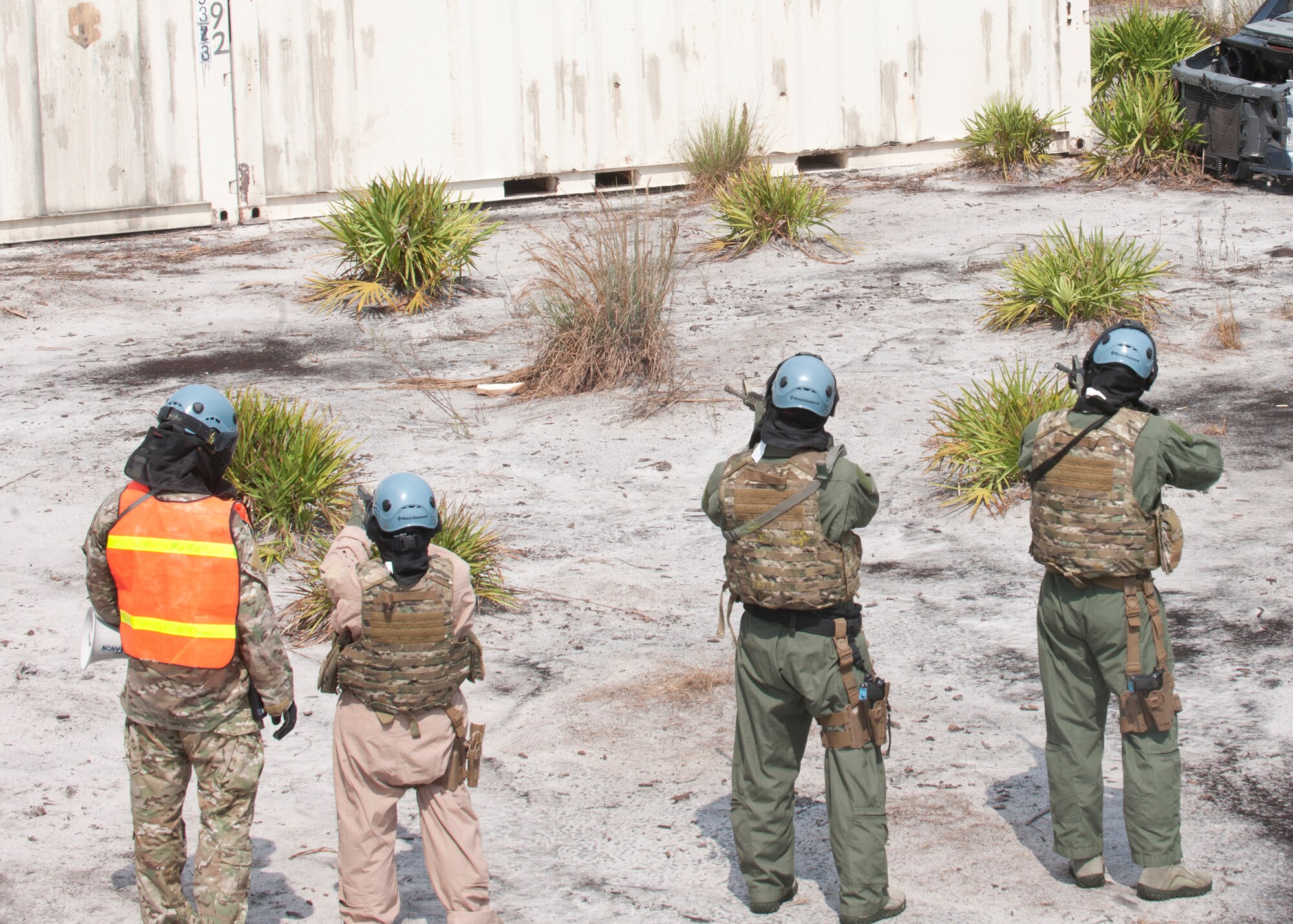 U.S. Air Force Staff Sgt. Joseph Dittmer, 347th Operations Support Squadron survival, evasion, resistance and escape specialist, instructs Airmen participating in a live fire scenario on how to use their weapons containing simulation rounds at the Grand Bay Bombing and Gunnery Range at Moody Air Force Base, Ga., Aug. 1, 2012. After a few rounds of target practice the SERE specialists tagged the three Airmen with paint balls as they attempted to return fire and run for cover during the scenario. (Courtesy photo) 