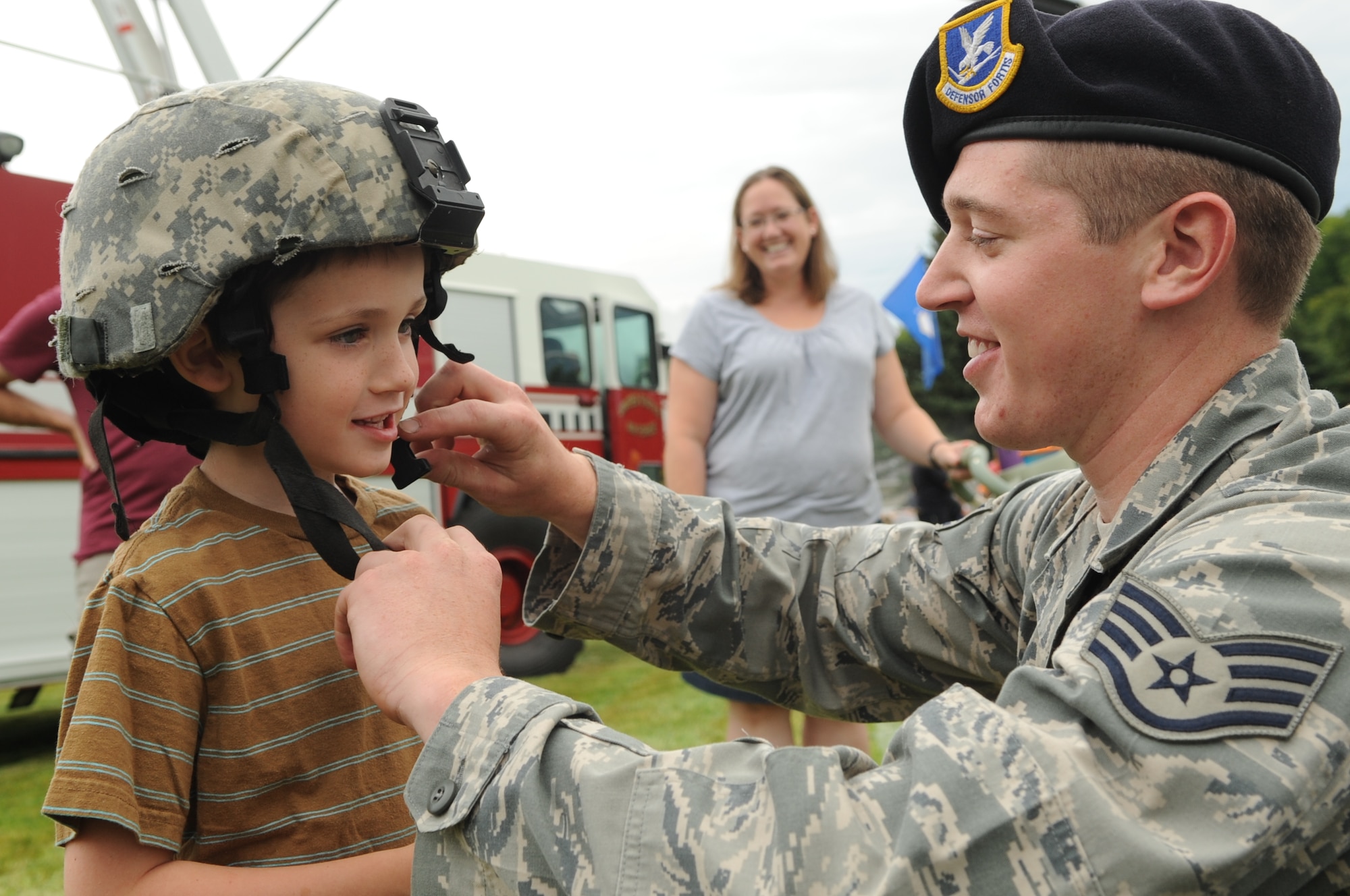 Staff Sgt Brandon Saliers, 319th Security Forces Squadron, gears up Issac Wild, 5, during the National Night Out Picnic in Grand Forks, N.D., on Aug 7, 2012. The National Night Out picnic is an event held to inform the community about law enforcement and fire safety. Events included a military working dog demonstration, weapons display, and a simulated house fire. (U.S. Air Force/Staff Sgt. Amanda N. Grabiec)