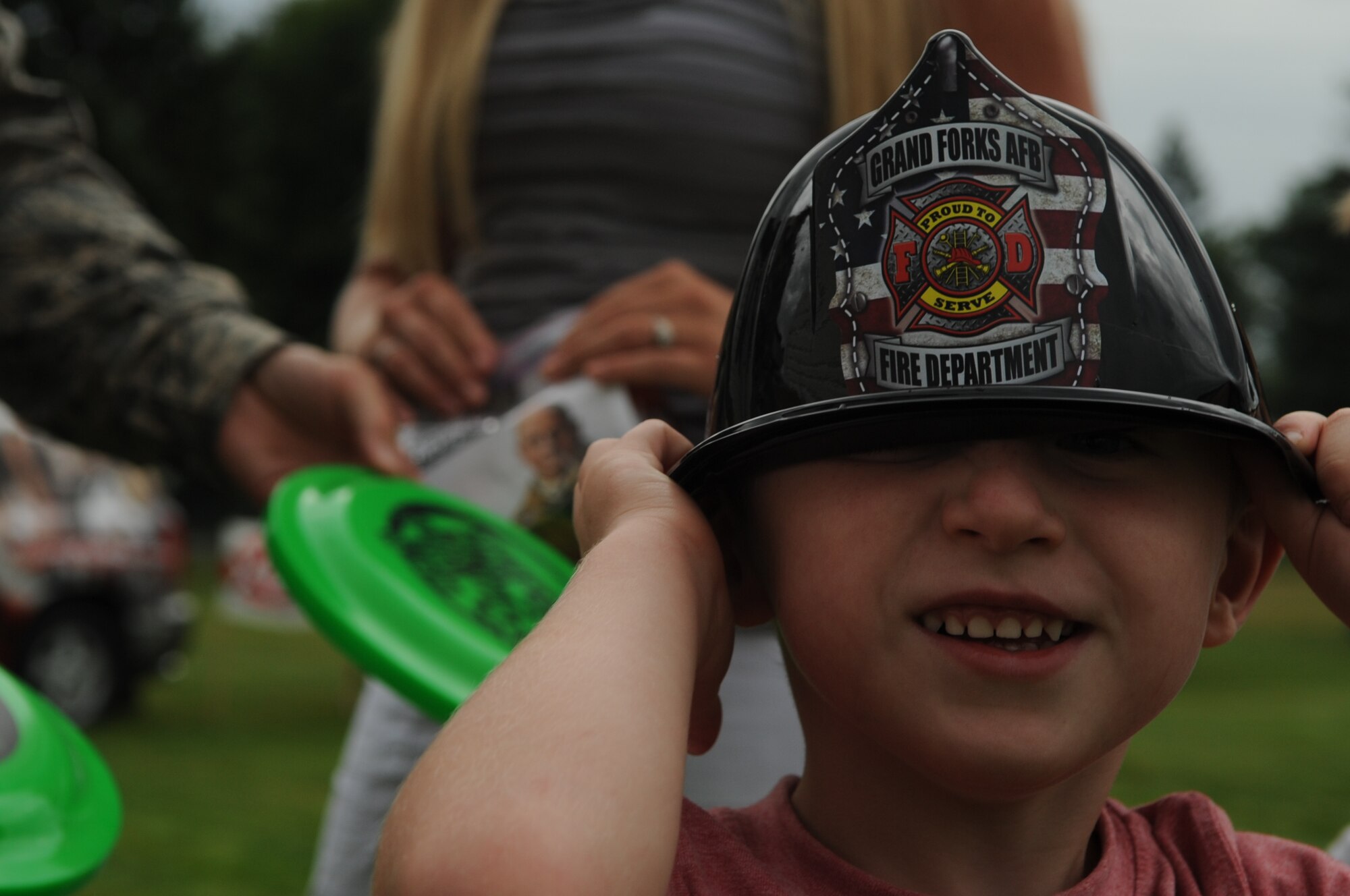 Macalster Noll, 3, puts on his souvenir Grand Forks Air Force Base fire helmet at the National Night Out Picnic in Grand Forks, N.D., on Aug 7, 2012. The National Night Out picnic is an event held to inform the community about law enforcement and fire safety. Events included a military working dog demonstration, weapons display, and a simulated house fire. (U.S. Air Force/Staff Sgt. Amanda N. Grabiec)