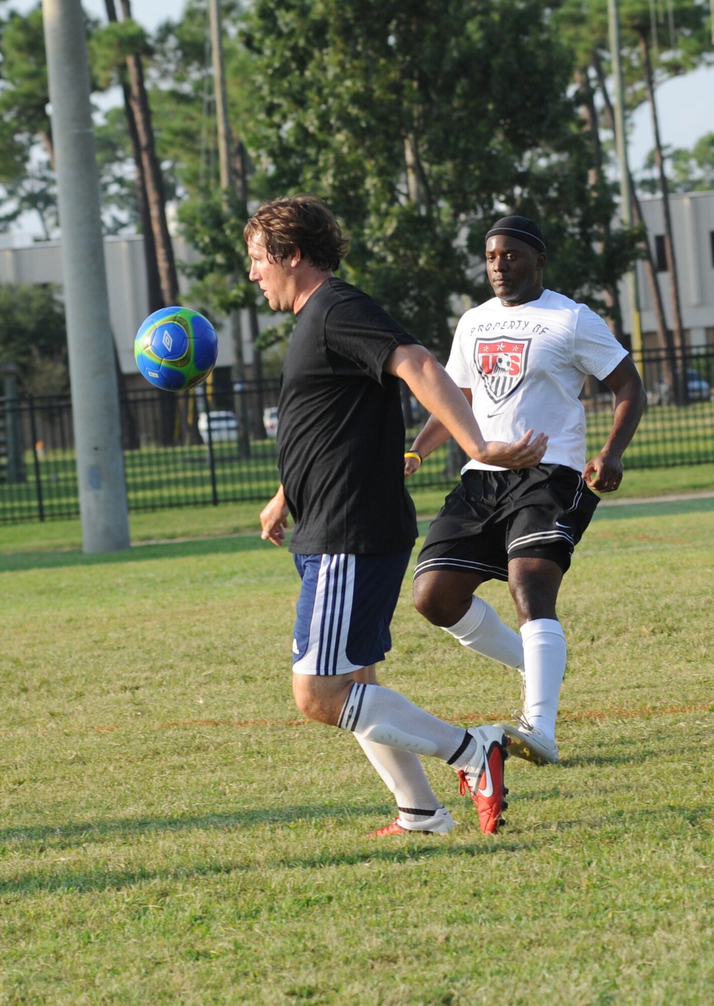 William Boxx, 85th Engineering Installation Squadron, bumps the soccer ball to the ground as Tony Bridgewater, 334th Training Squadron, approaches from behind during an intramural soccer game August 7, 2012, at Keesler Air Force Base, Miss.  The Gators defeated the 85th 6-2.  (U.S. Air Force photo by Kemberly Groue)